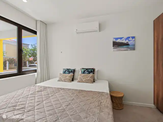 The Wharf 1D - au cœur de Willemstad | Curaçao, Curaçao-Centre, Willemstad - appartement La chambre principale dispose d’un lit king-size confortable, de la climatisation, d’une grande armoire intégrée et de sa propre télévision connectée.