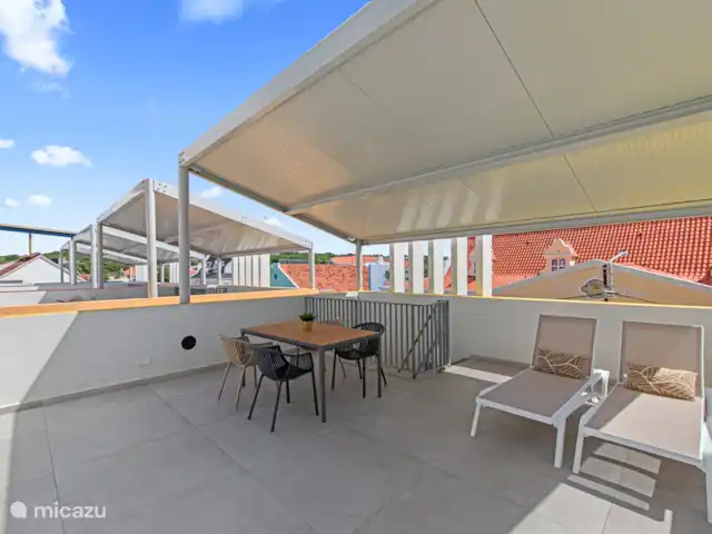The Wharf 1D - au cœur de Willemstad | Curaçao, Curaçao-Centre, Willemstad - appartement Terrasse privée sur le toit avec canapé de salon, table à manger et lits de salon.