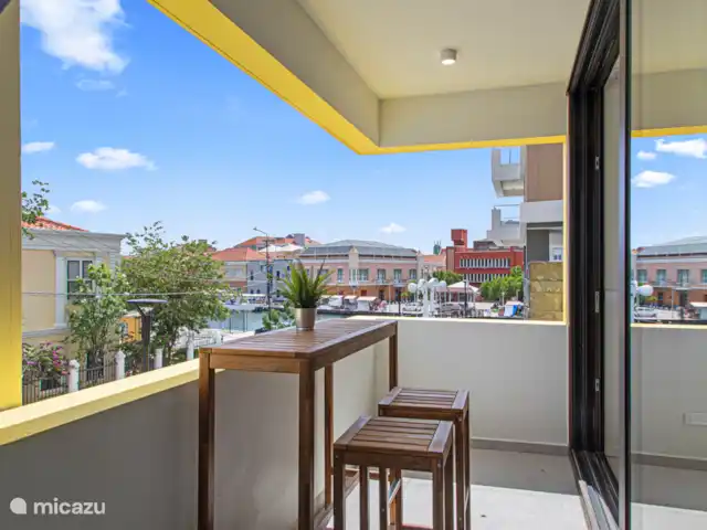 The Wharf 1D - au cœur de Willemstad | Curaçao, Curaçao-Centre, Willemstad - appartement Prenez votre café du matin ou votre boisson du soir sur le balcon tout en admirant le port animé et le paysage urbain coloré.