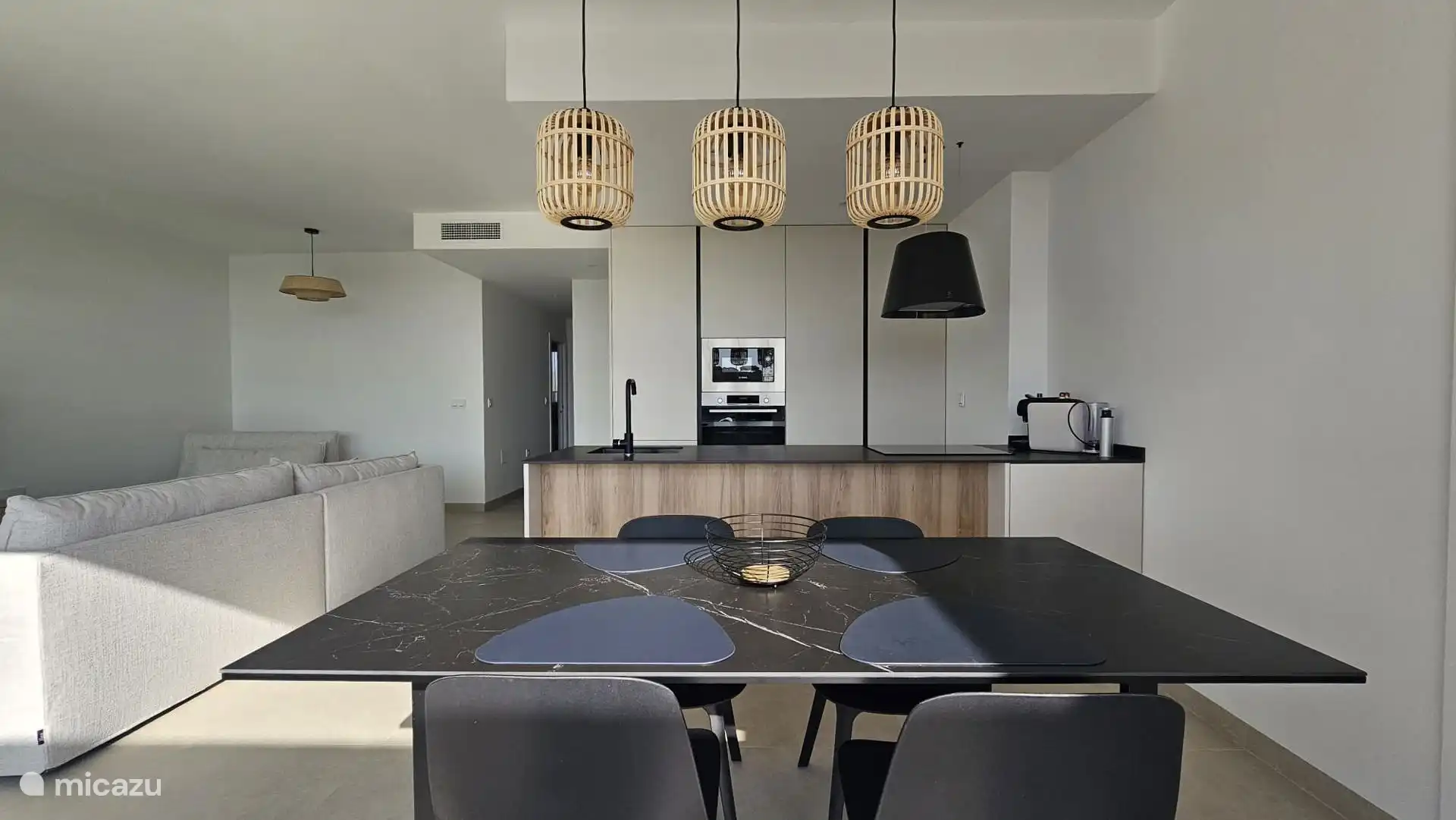 Modernes Wohnzimmer mit offener Küche und bodentiefen Schiebefenstern mit viel Licht