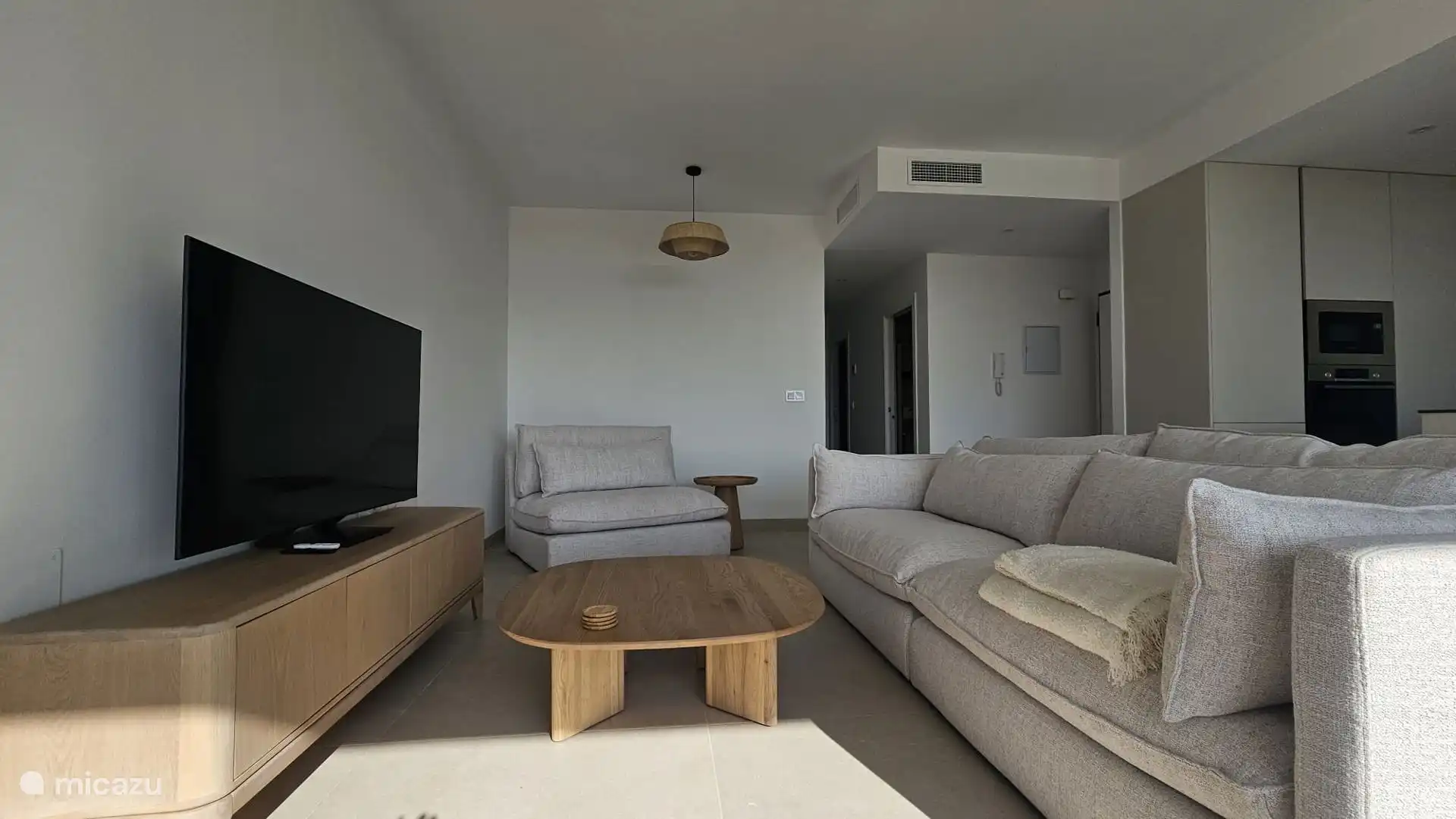 Modernes Wohnzimmer mit offener Küche und bodentiefen Schiebefenstern mit viel Licht