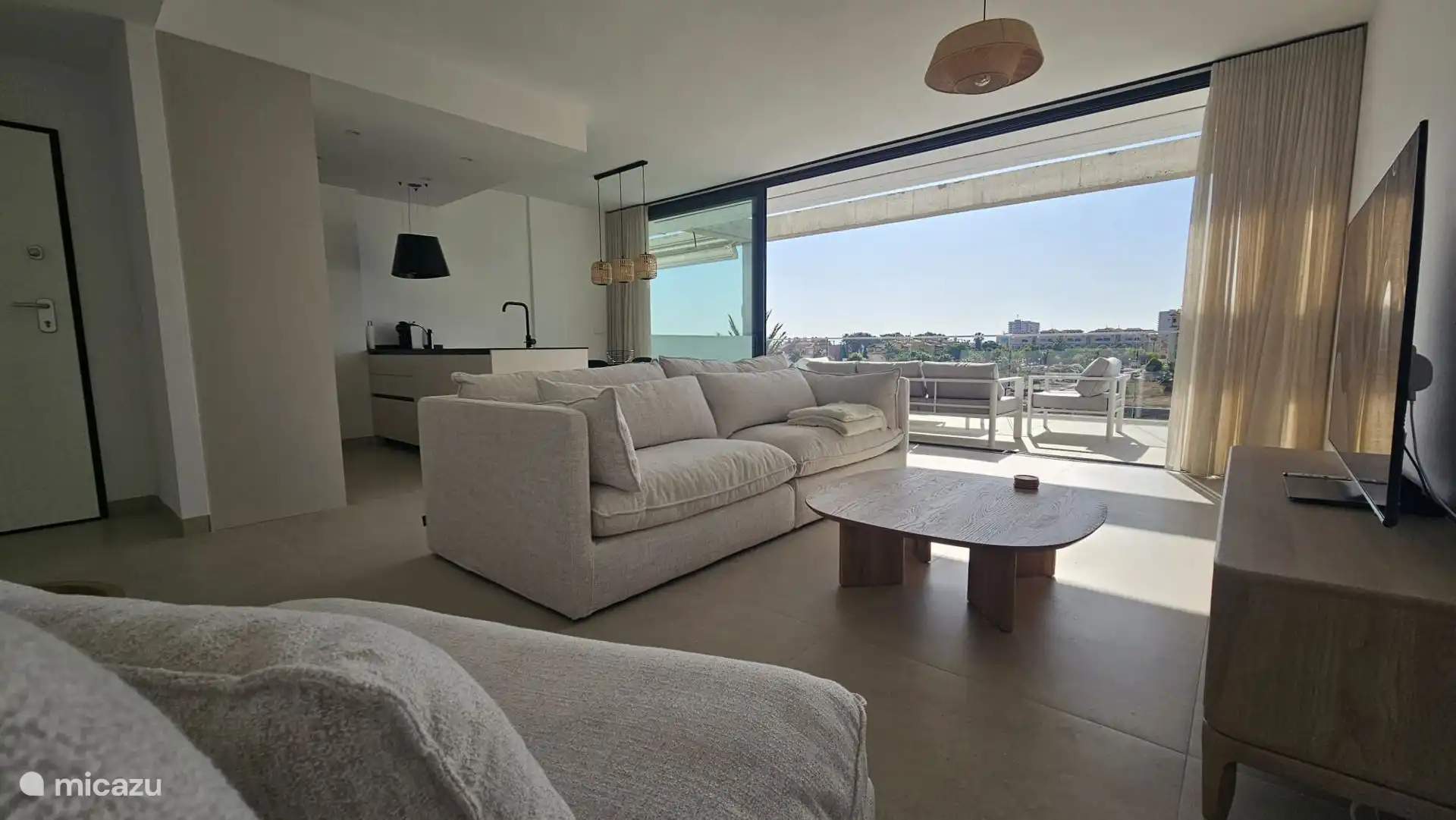 Modernes Wohnzimmer mit offener Küche und bodentiefen Schiebefenstern mit viel Licht