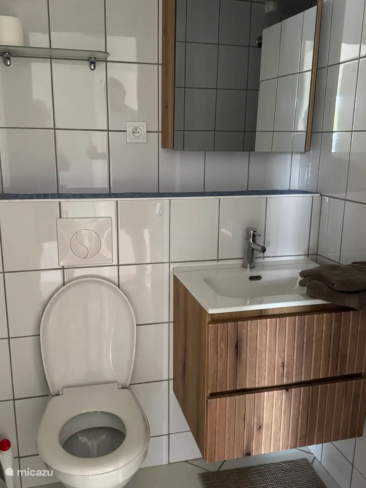 Deuxième salle de bain avec WC, lavabo avec tiroirs, armoire miroir et douche. 