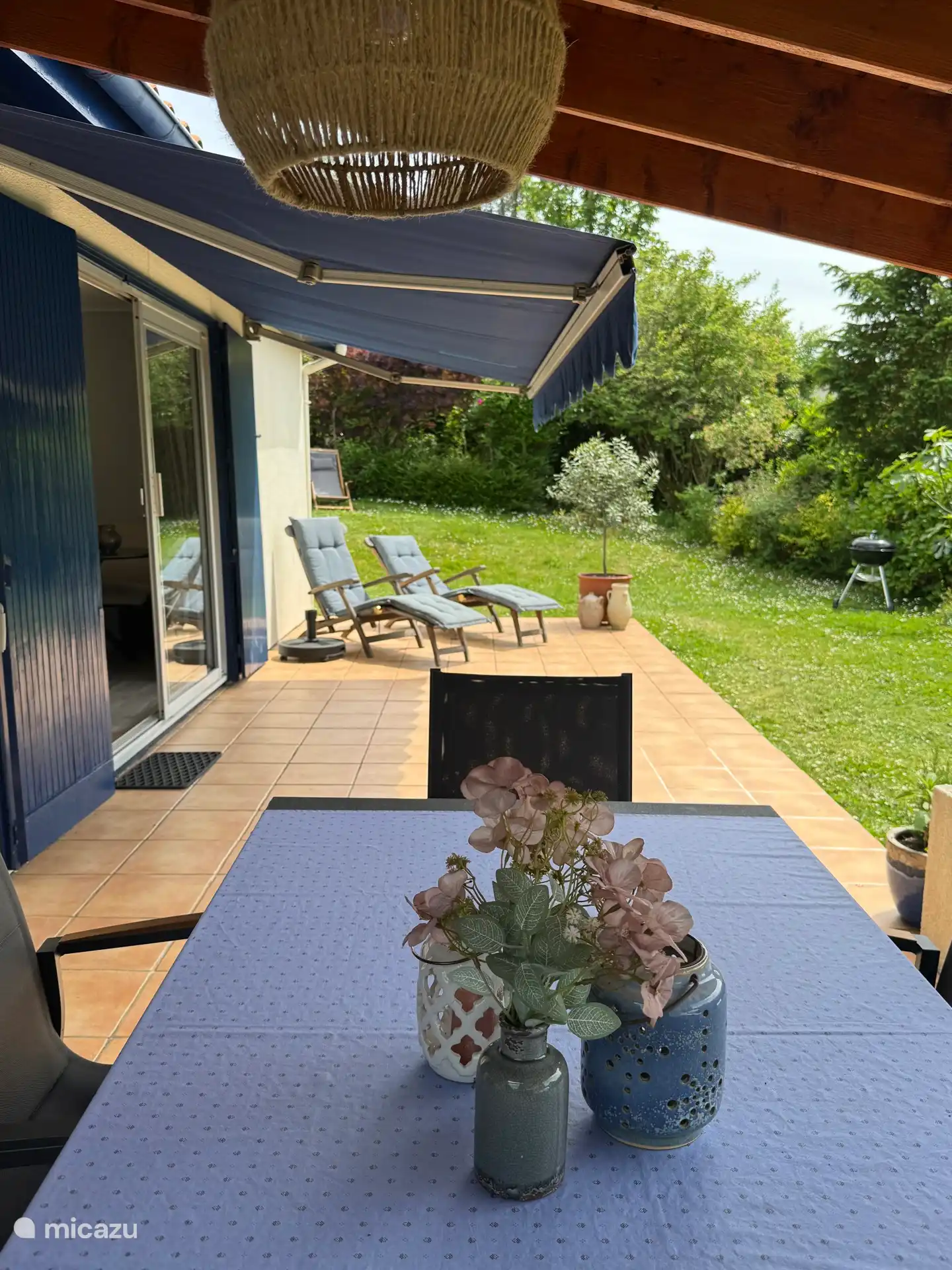Vue sur la terrasse depuis la canopée avec table extérieure et chaises. 