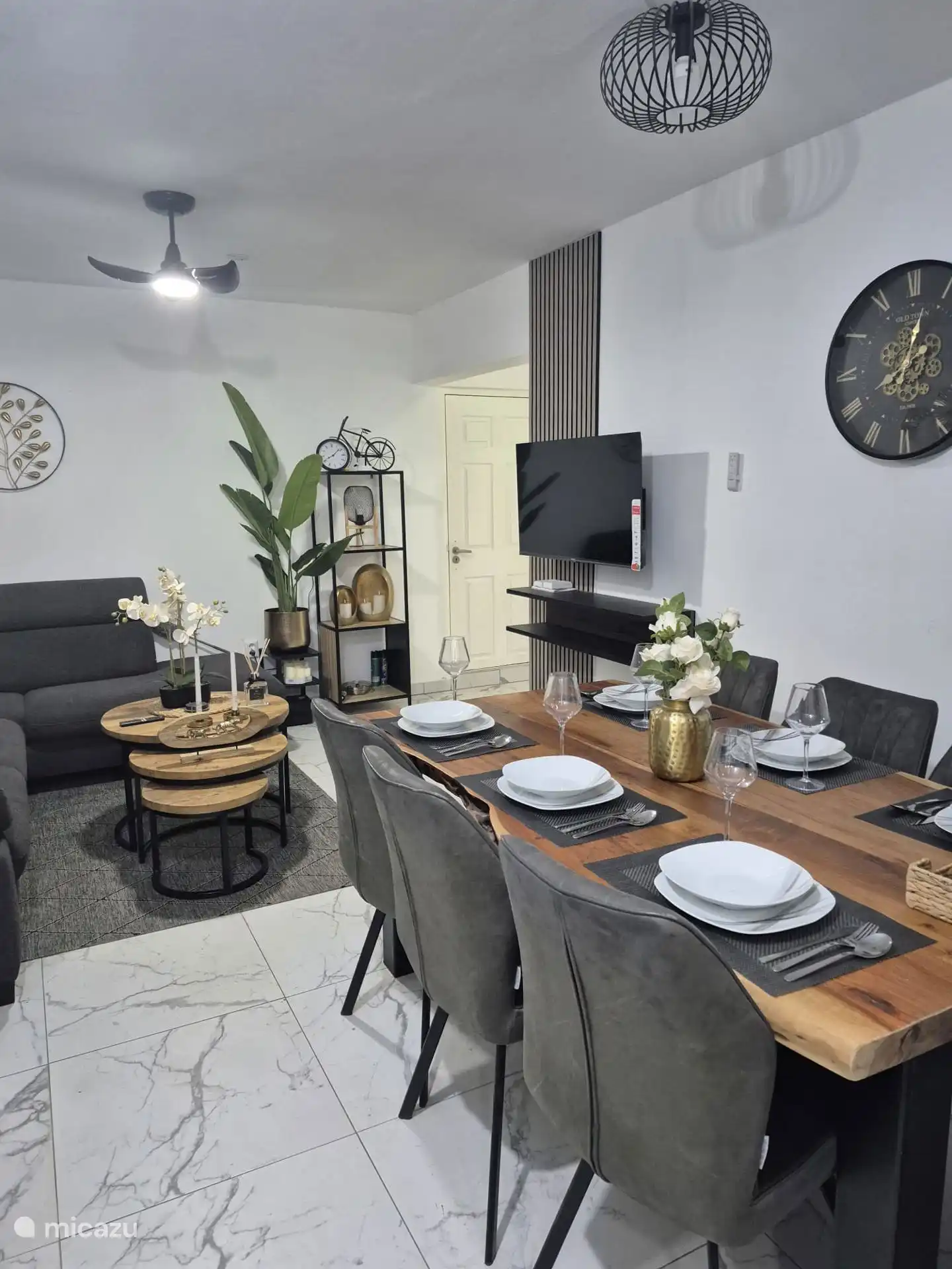 Un salon spacieux avec une grande table à manger, équipé de sièges confortables pour six personnes.