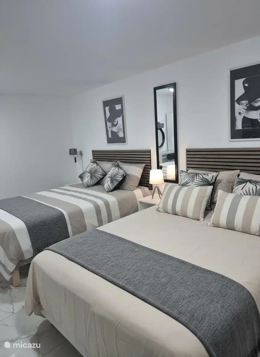 Chambre spacieuse pour 4 personnes, équipée de deux lits doubles confortables et de la climatisation.