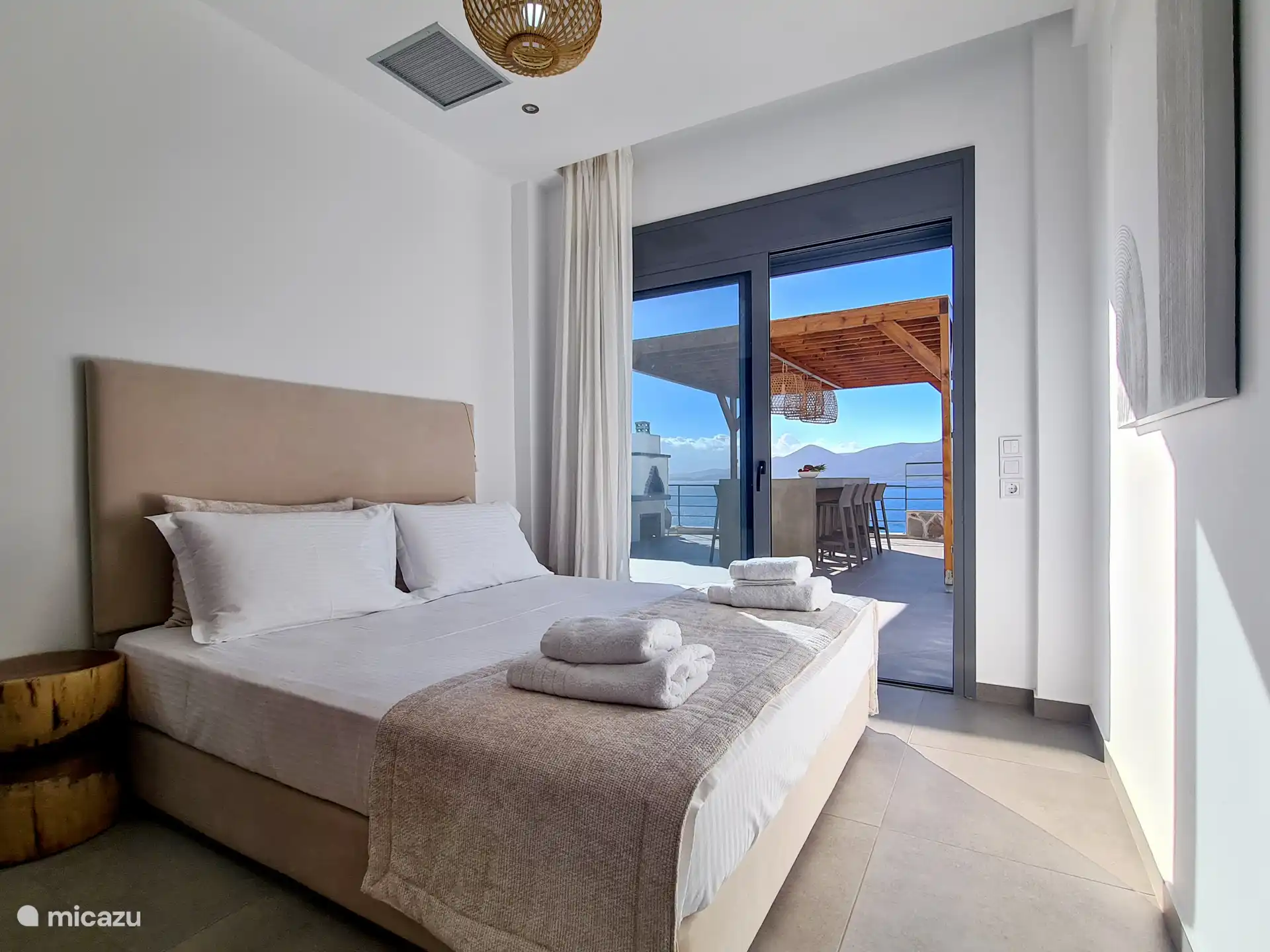 Hauptschlafzimmer mit direktem Zugang zum Esstisch und atemberaubender Aussicht auf das Meer und die Berge