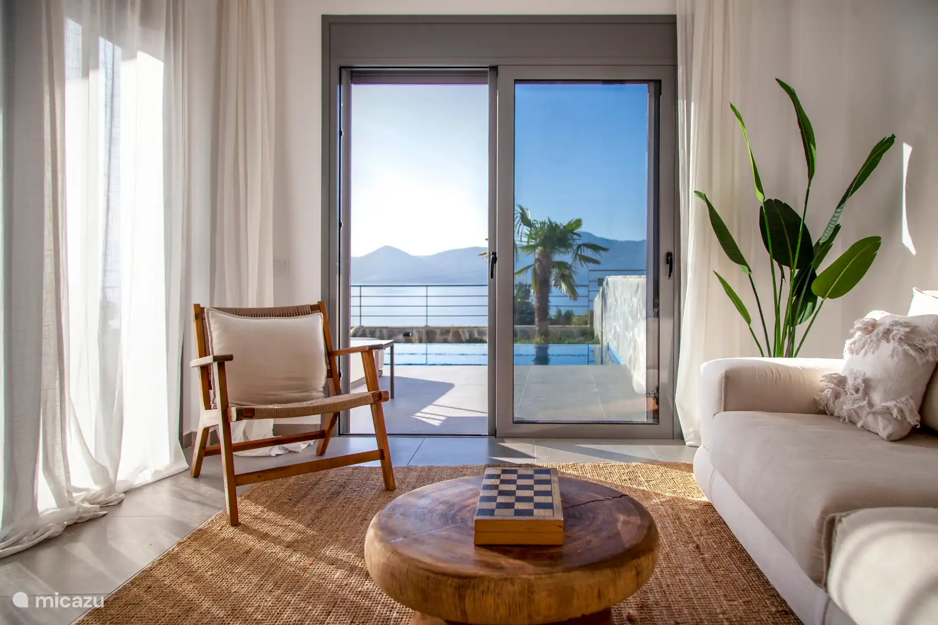 Wohnzimmer, hell, luftig und mit Aussicht – viel Sitzbereich, großes Sofa und Smart-TV