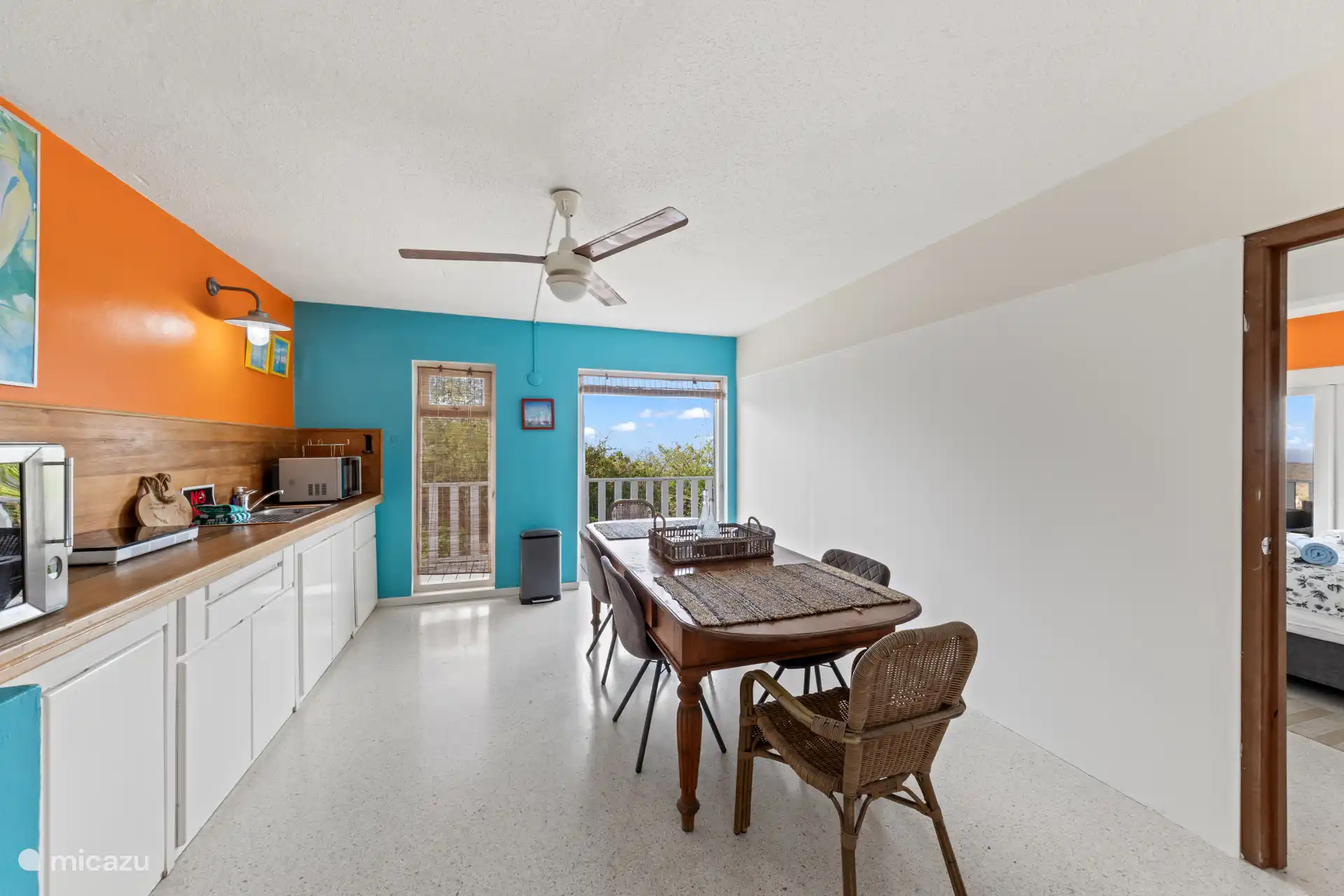 Kitchenette met eettafel met toegang tot balkon.