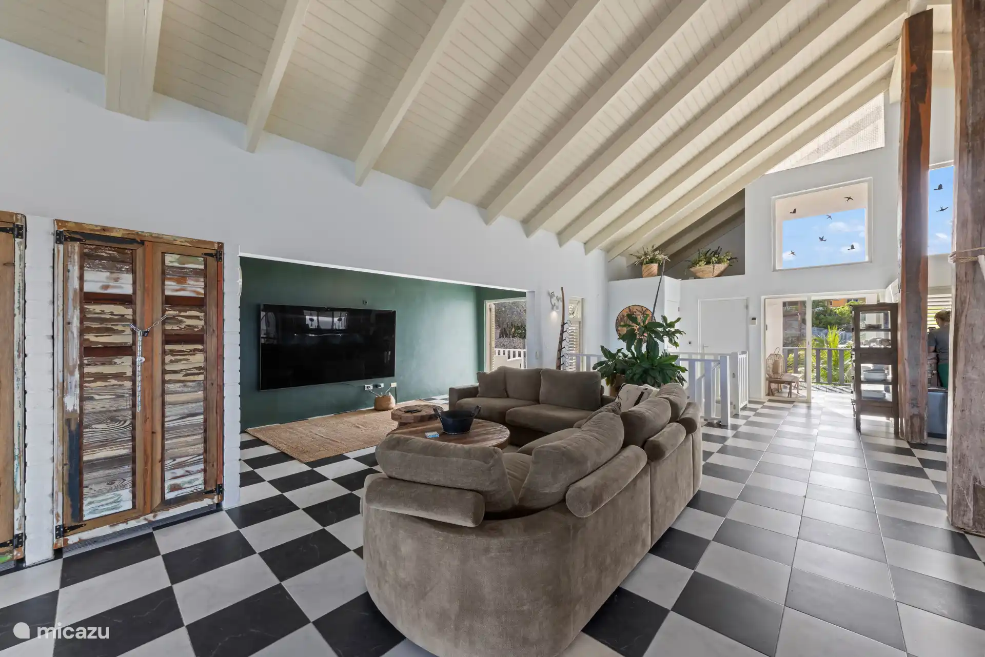 Grote woonkamer met hoge plafonds en een 98-inch tv