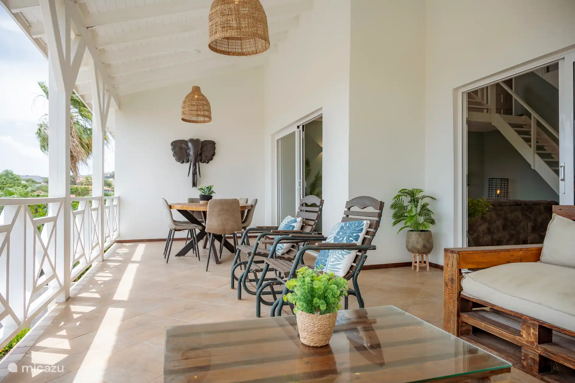 Balcón espacioso con una brisa del mar. En el balcón hay una mesa de comedor, un salón y dos mecedores