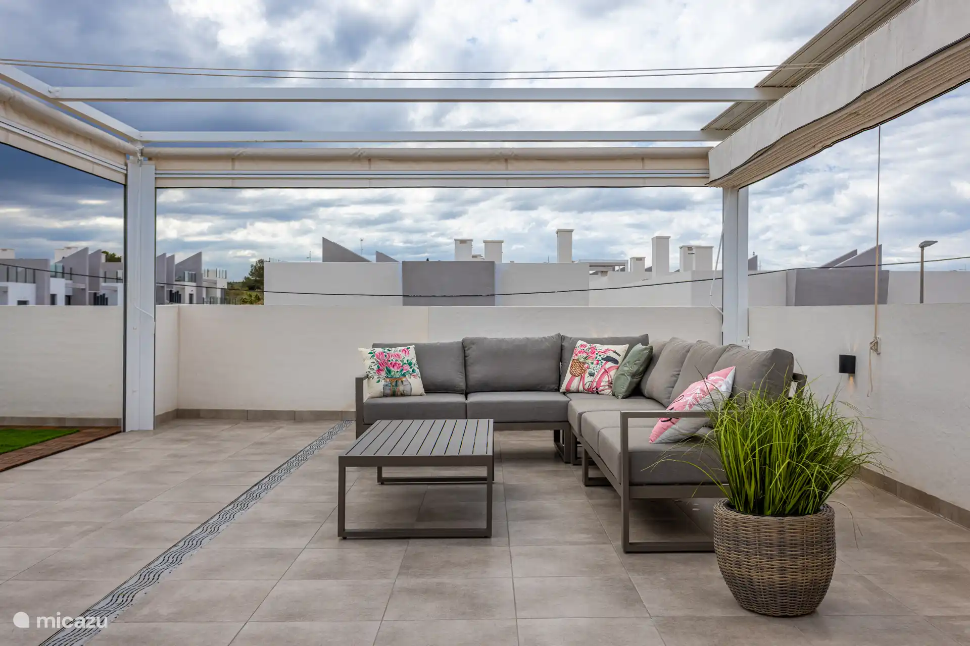 Lounge zit onder de pergola. 