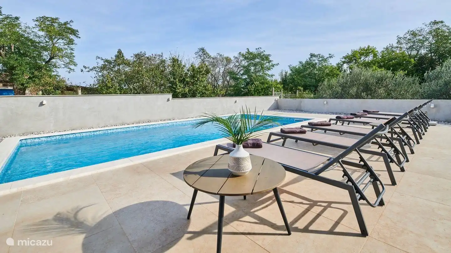 Schwimmbecken und Sonnenliege