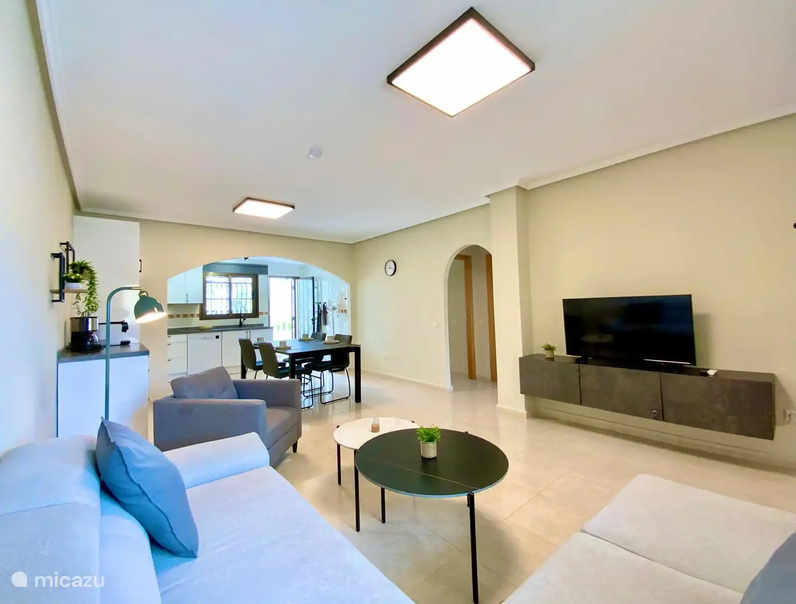 Wohnzimmer mit moderner Einrichtung, offenem Grundriss und direkter Verbindung zur Küche und zum Essbereich