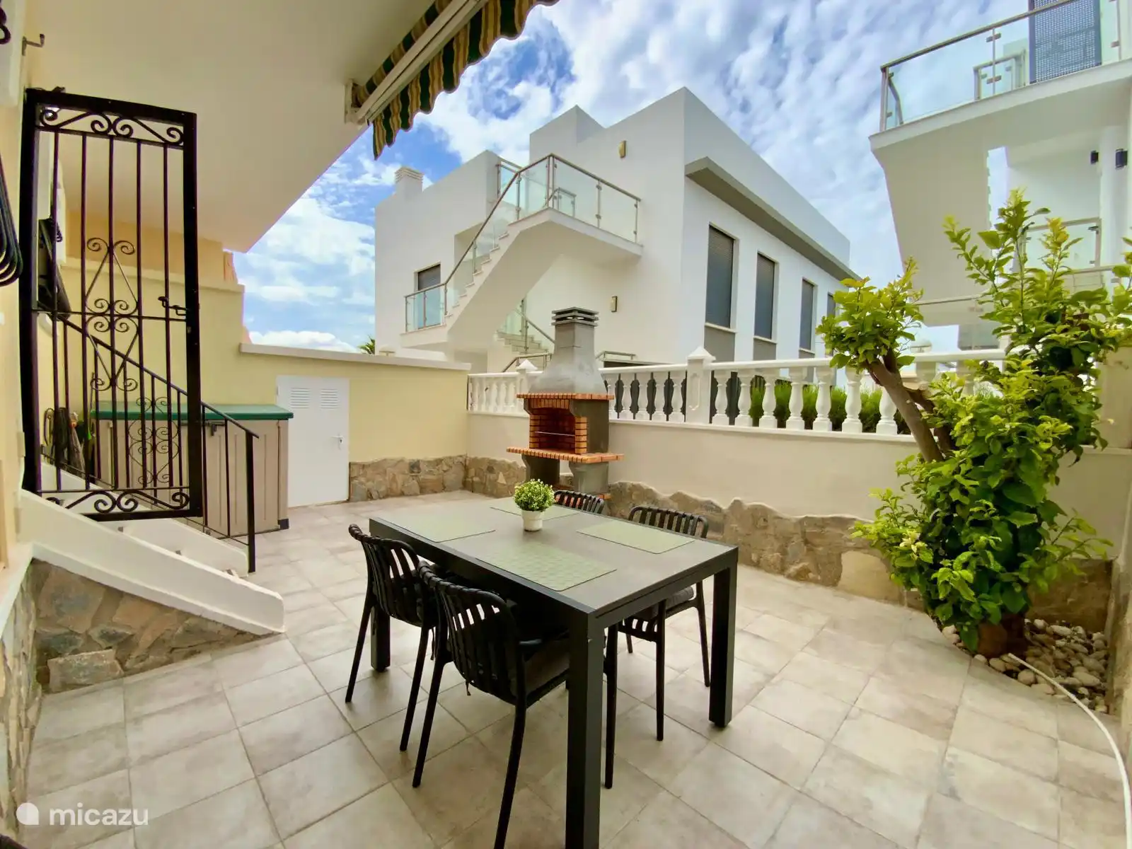 Gemütliche Terrasse hinten mit Esstisch, Grill und viel Privatsphäre – ideal, um die Natur in Ruhe zu genießen.