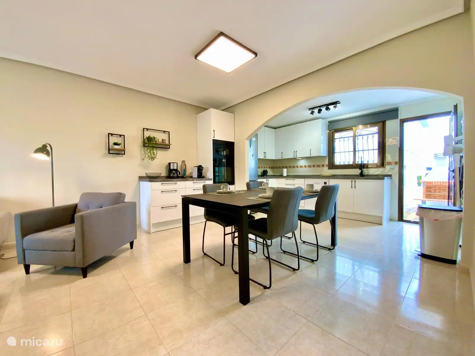 Helle und moderne Küche mit einer gemütlichen Kaffeeecke und stilvollem Essbereich, voll ausgestattet für komfortables Kochen und Essen