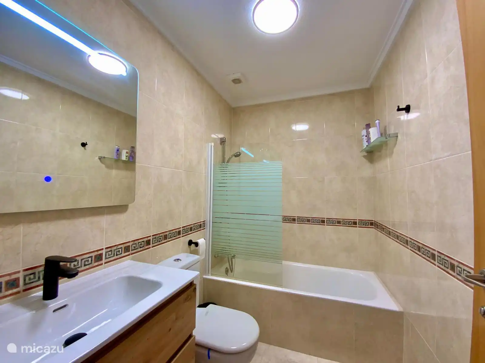 Gut gepflegtes eigenes Badezimmer mit Badewanne, Toilette und modernem Waschbecken ausgestattet