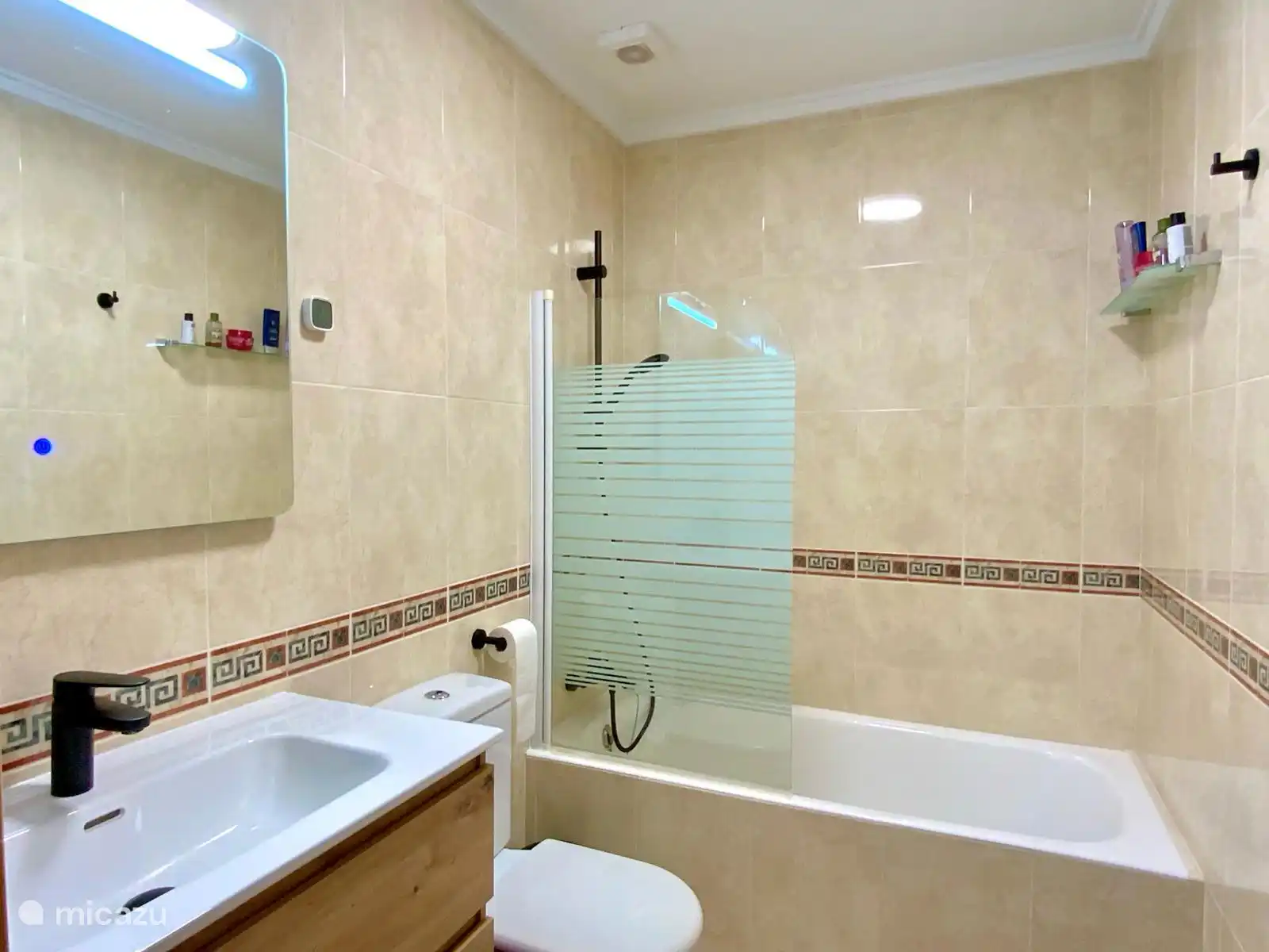 Verzorgde ensuite badkamer uitgerust met een ligbad, toilet en moderne wastafel