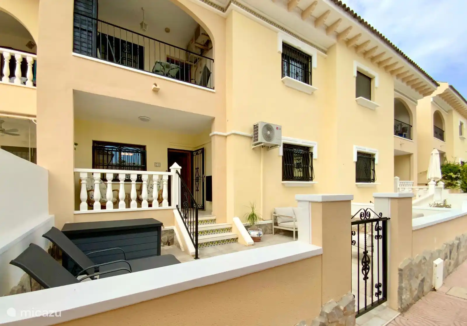 Die Vorderseite des Hauses mit Lounge-Terrasse und Sonnenliegen