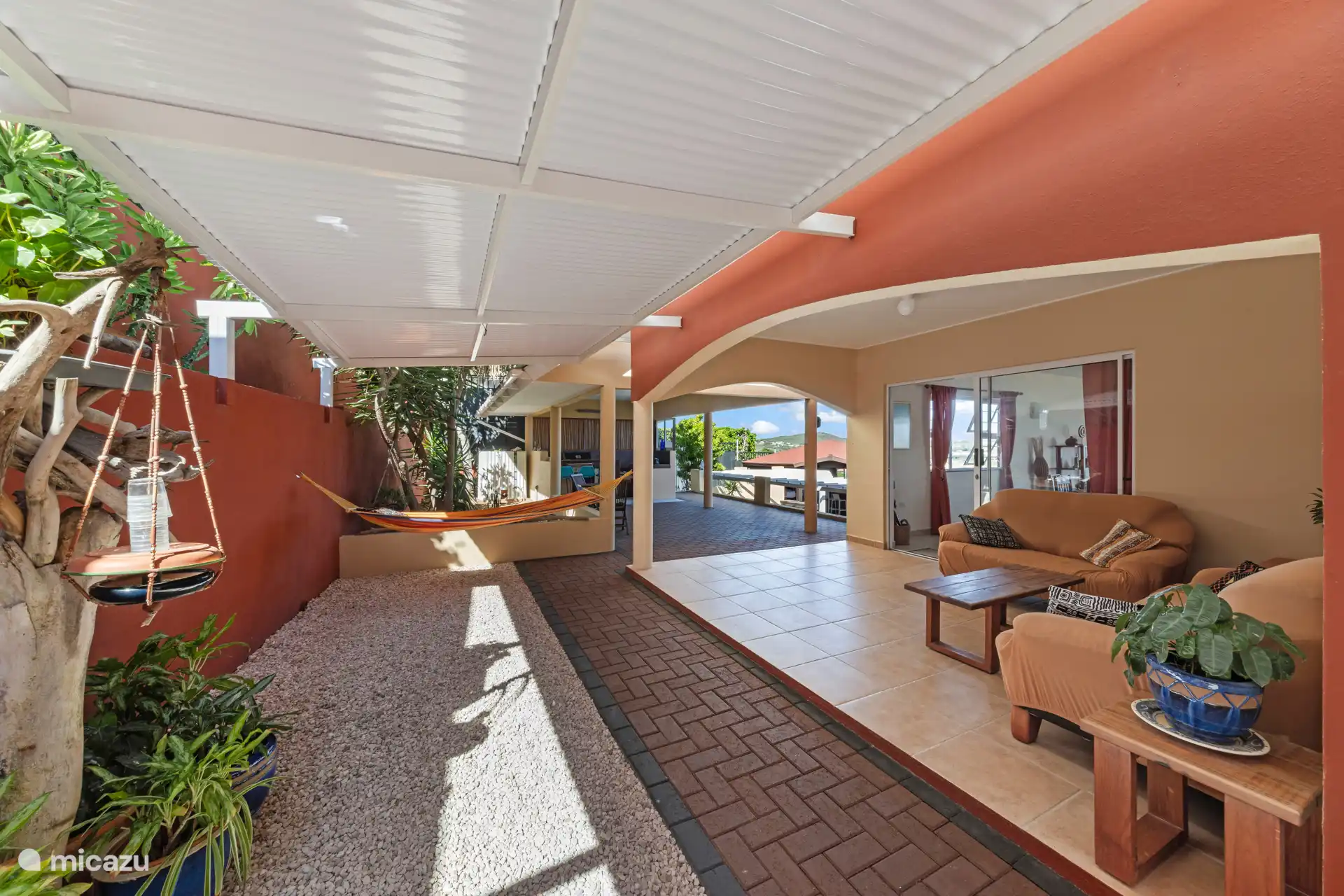 Sfeervol overdekt terras met loungehoek en hangmat, perfect om te relaxen en te genieten van de Caribische bries