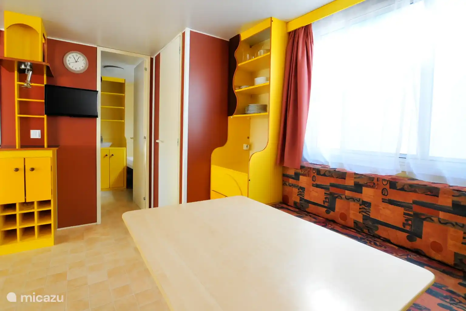 Bright and practical living room with dining table, kitchen and sitting area