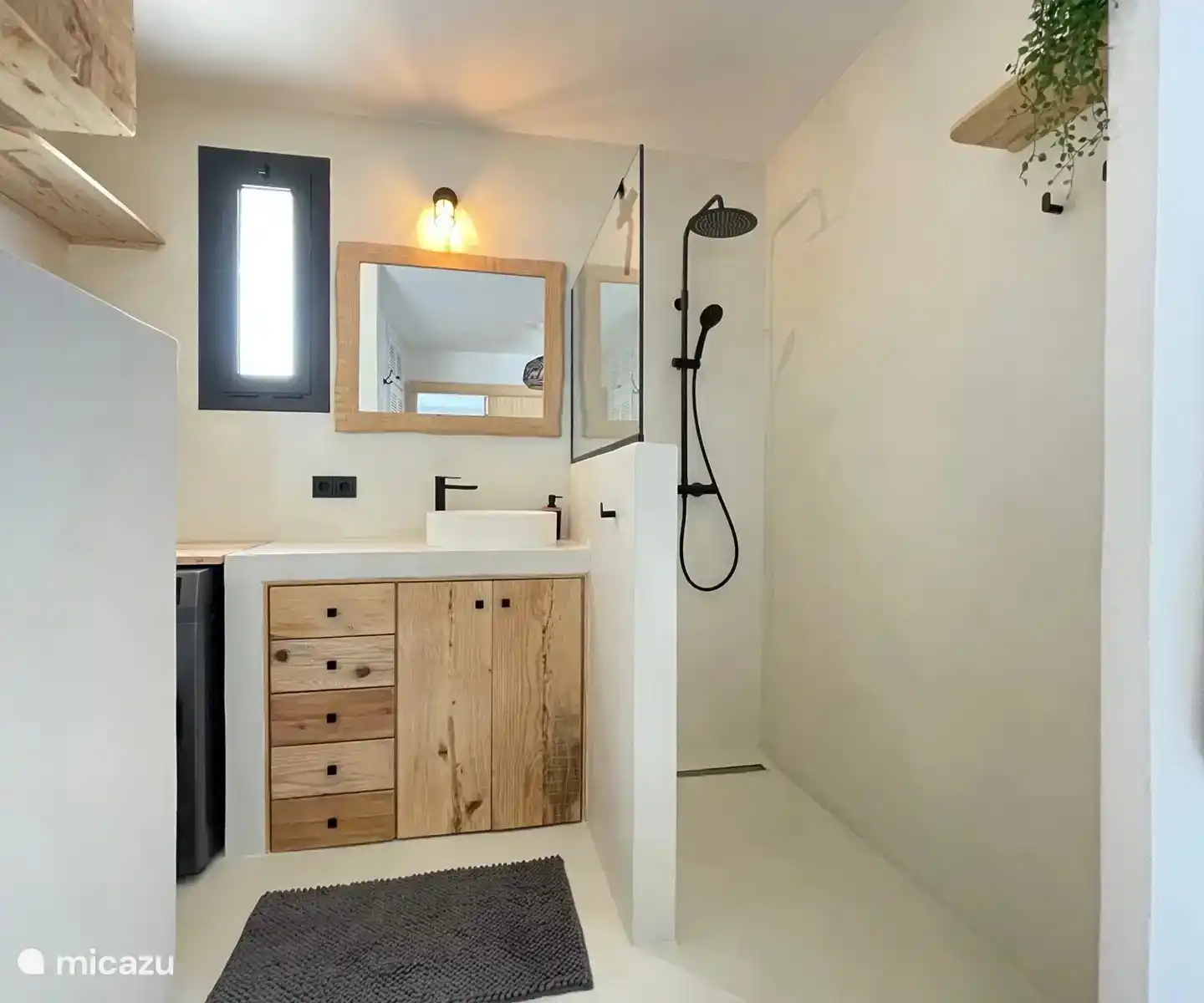 Integriertes Badezimmer mit begehbarer Dusche, Waschbecken, Toilette und Waschmaschine und Trockner.