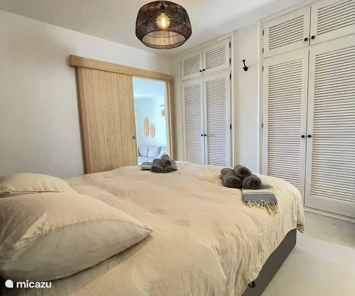 Geräumiges Schlafzimmer mit Klimaanlage, großem Doppelbett (180x210), viel Platz im Kleiderschrank und integriertem Bad mit begehbarer Dusche, Waschbecken und Toilette.