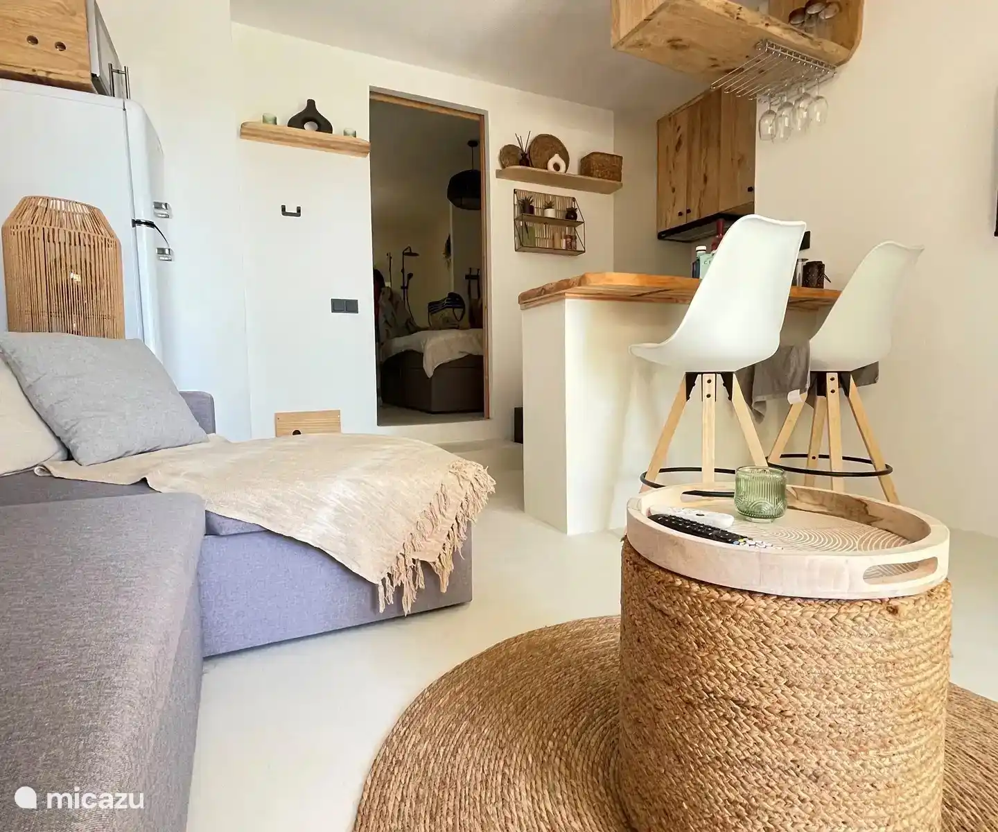 Gemütliches Wohnzimmer im Ibiza-Stil mit integrierter Küche. Vom Wohnzimmer aus hat man einen Blick aufs Meer.