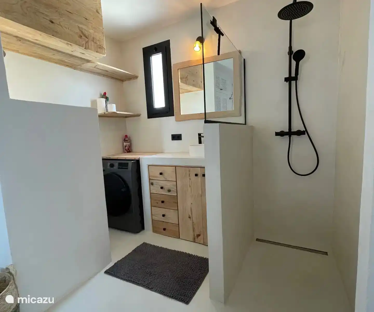 Integriertes Badezimmer mit begehbarer Dusche, Waschbecken, Toilette und Waschmaschine und Trockner.