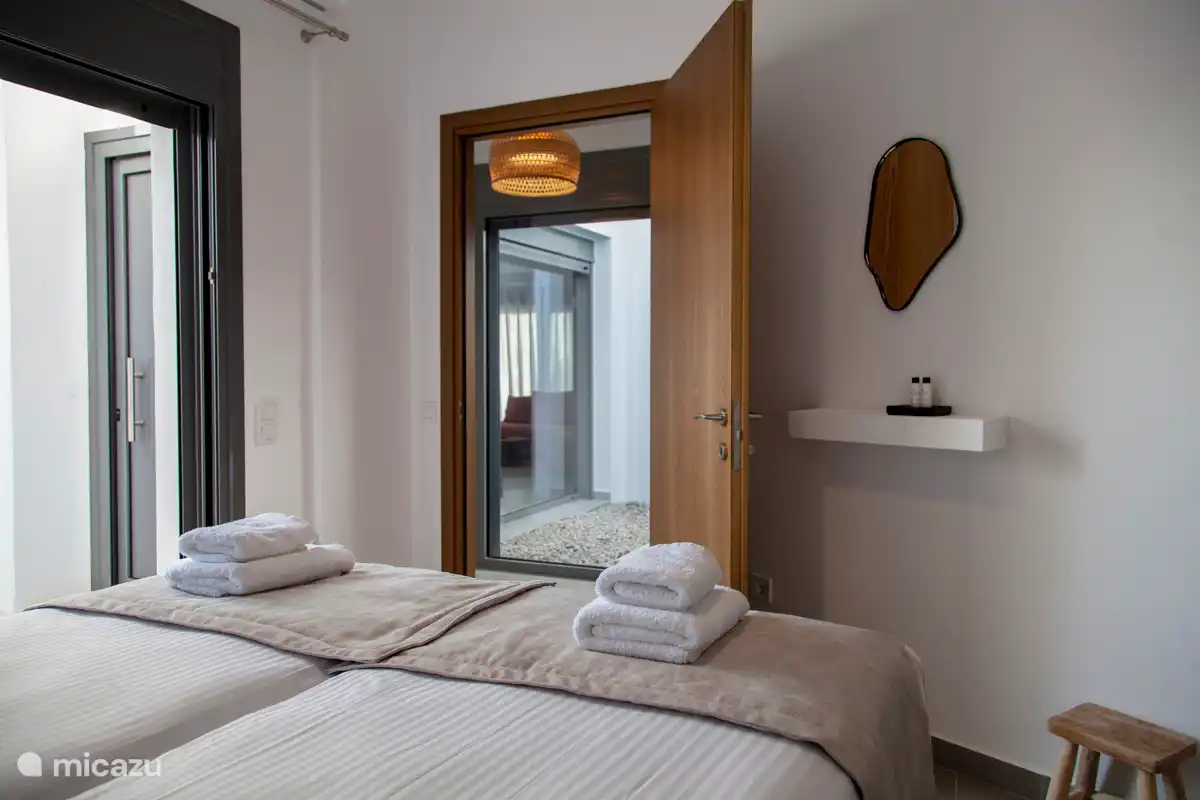 Schlafzimmer 2 mit Doppelbetten und einem kleinen Schminkspiegel