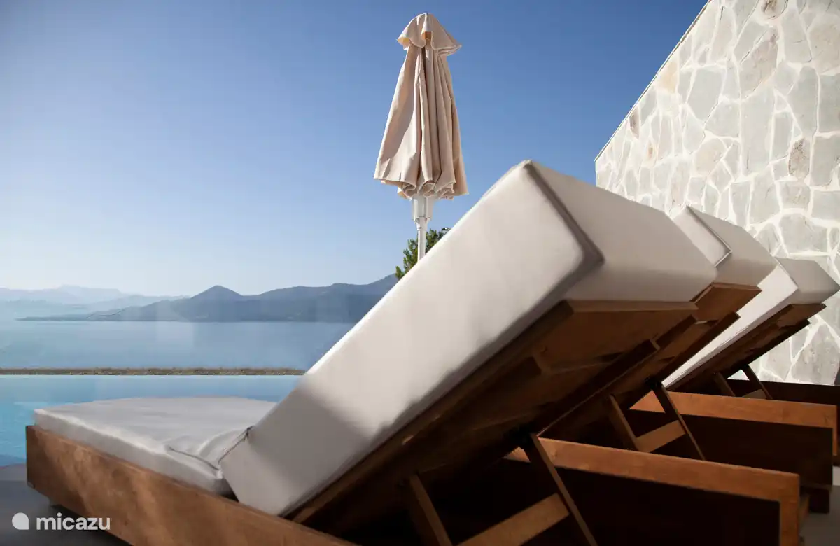 Bequeme Sonnenbetten mit Blick auf die Bucht von Paleros und die Insel Lefkas.