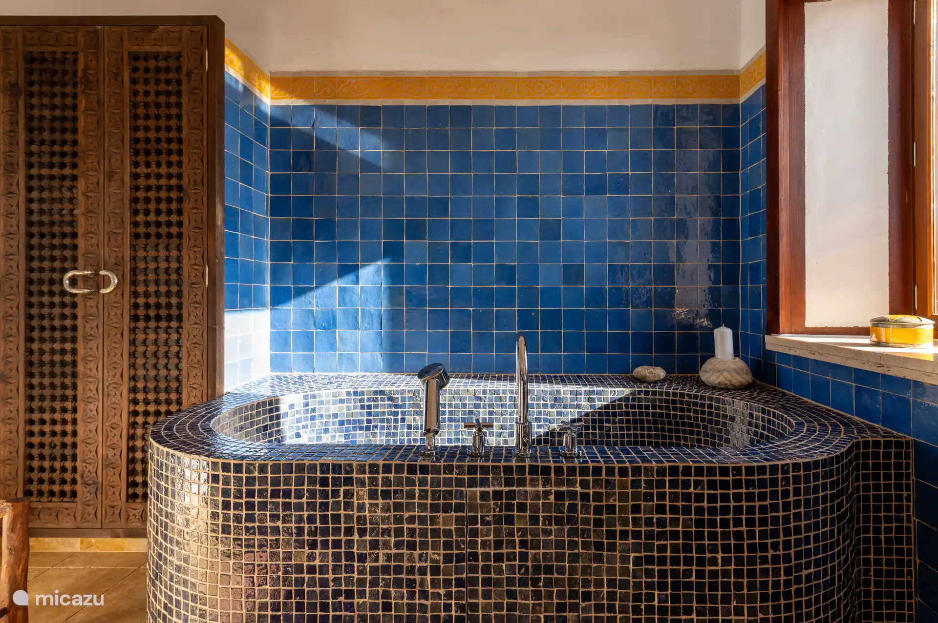 De ensuite badkamer is voorzien van een royale wastafel, bad en toilet.