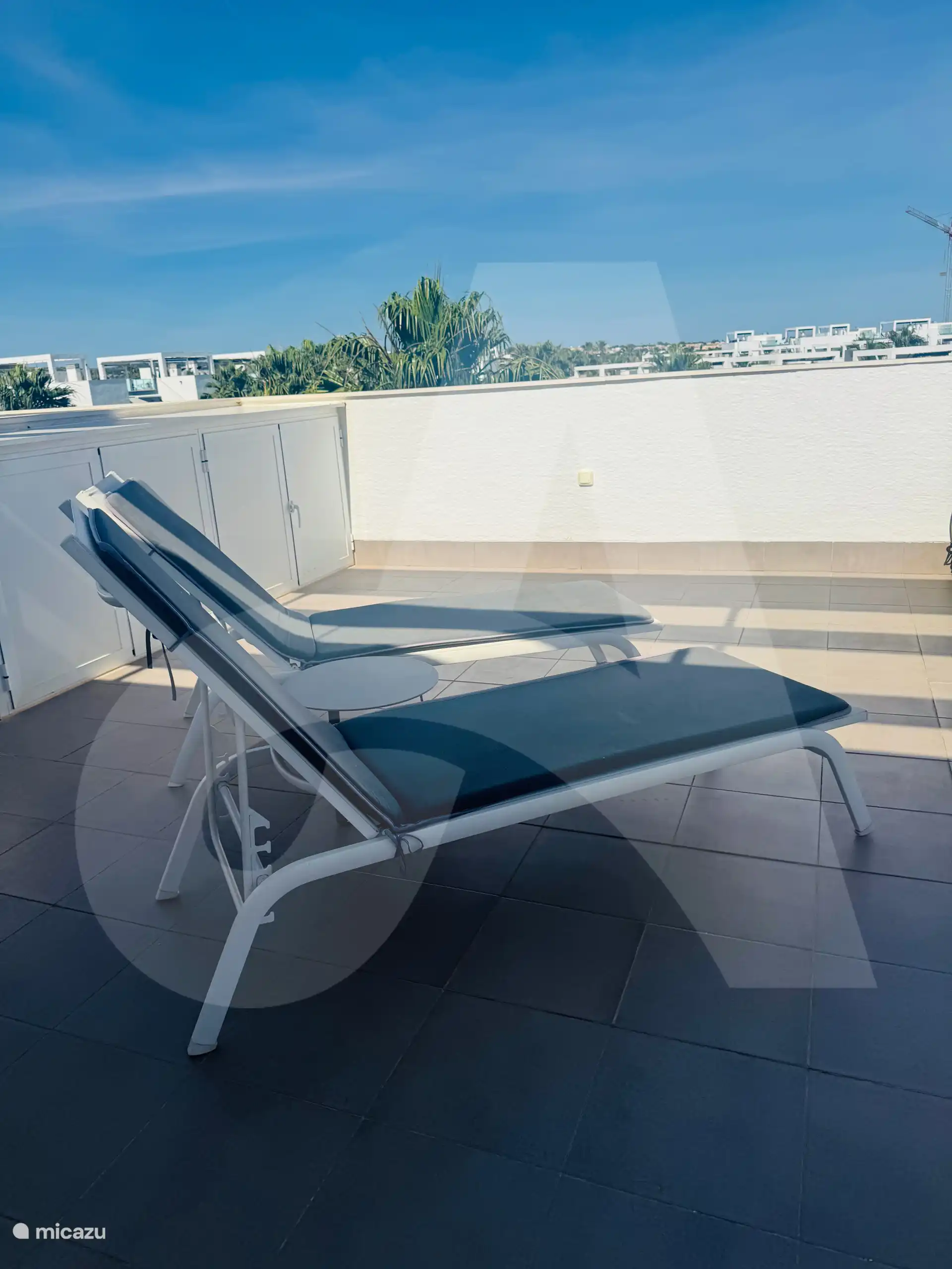 Ligstoelen op dakterras