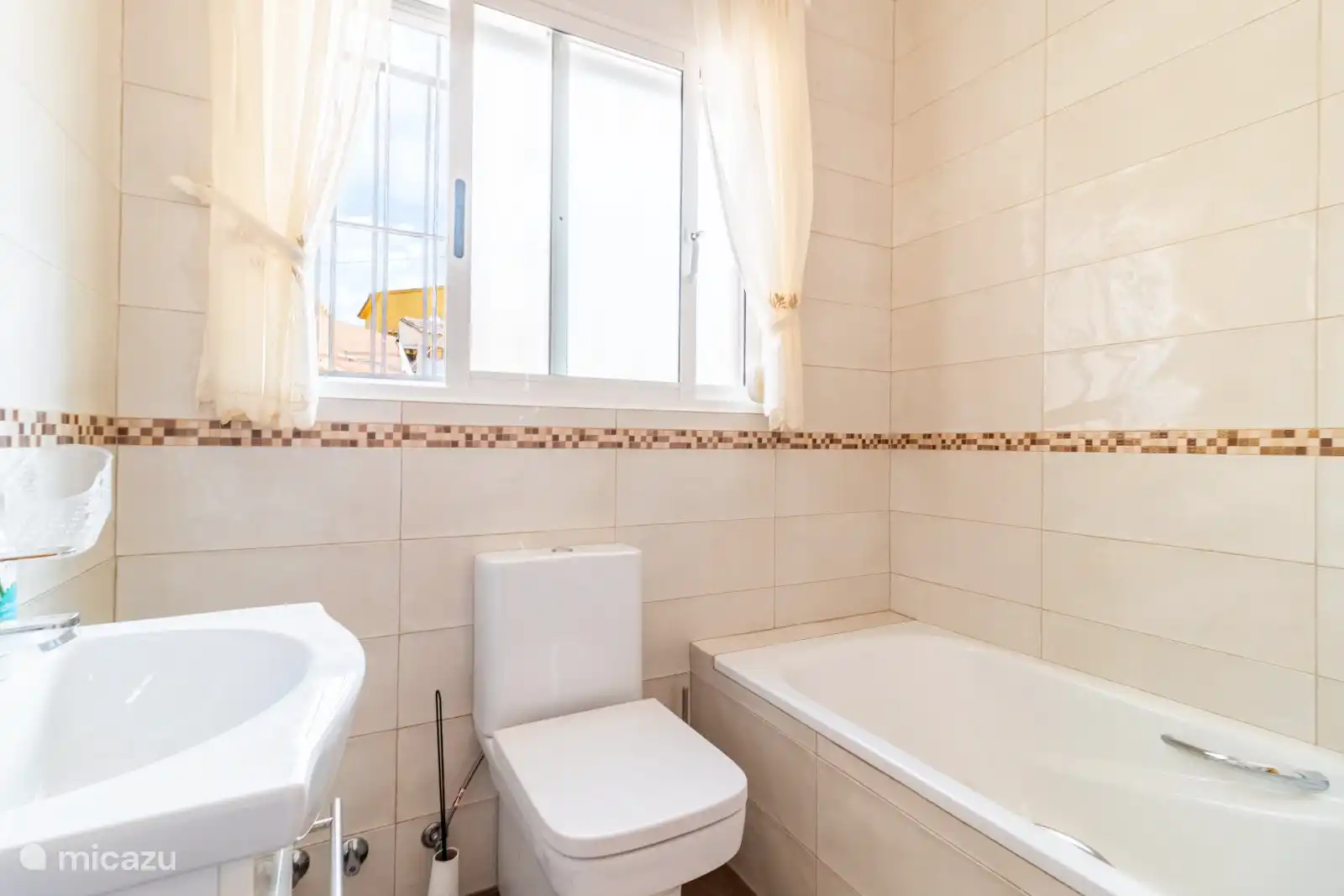 Salle de bain 1 avec baignoire, toilettes et fontaine d’eau