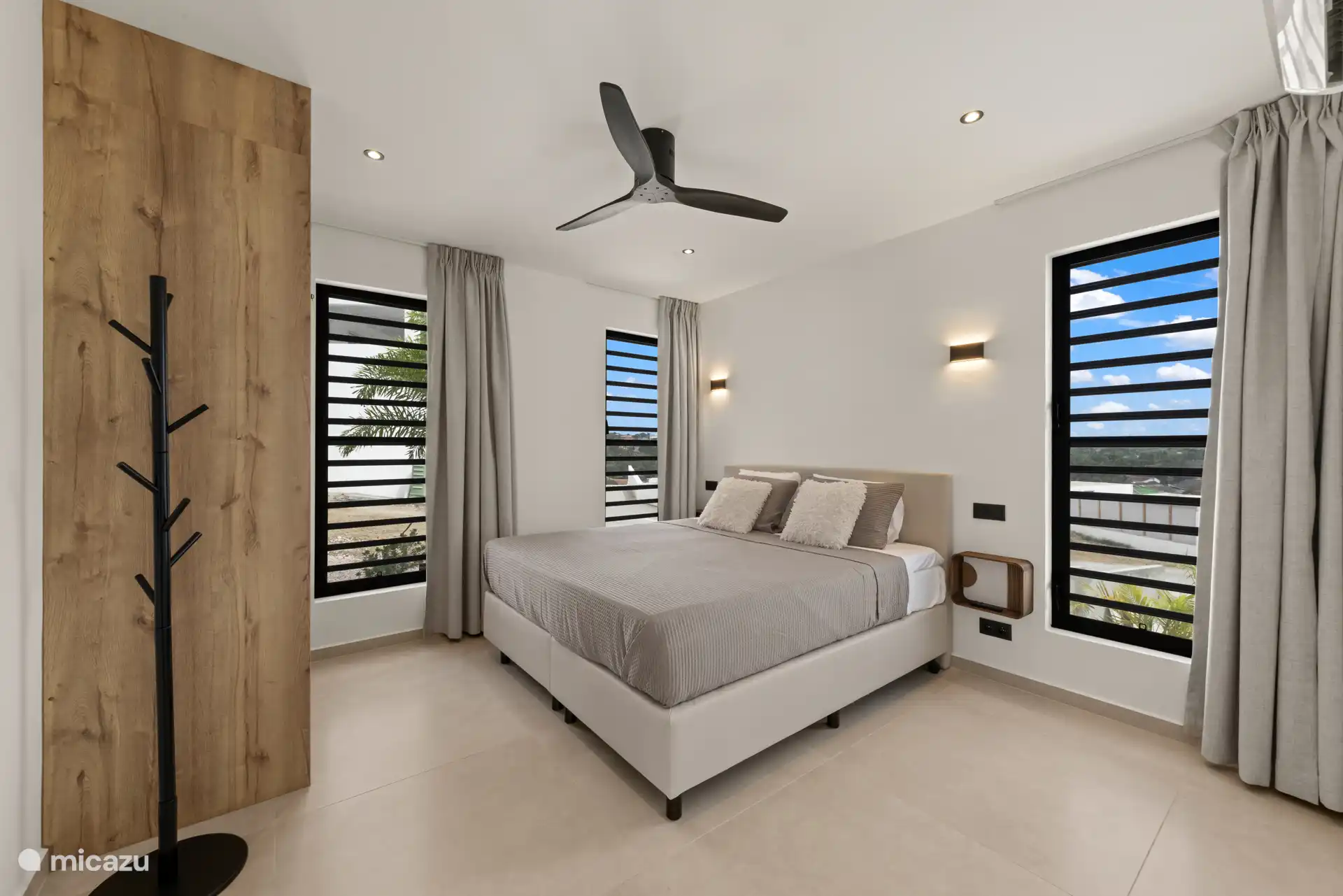 Slaapkamer met comfortabel tweepersoonsbed, plafondventilator en rustige uitstraling.