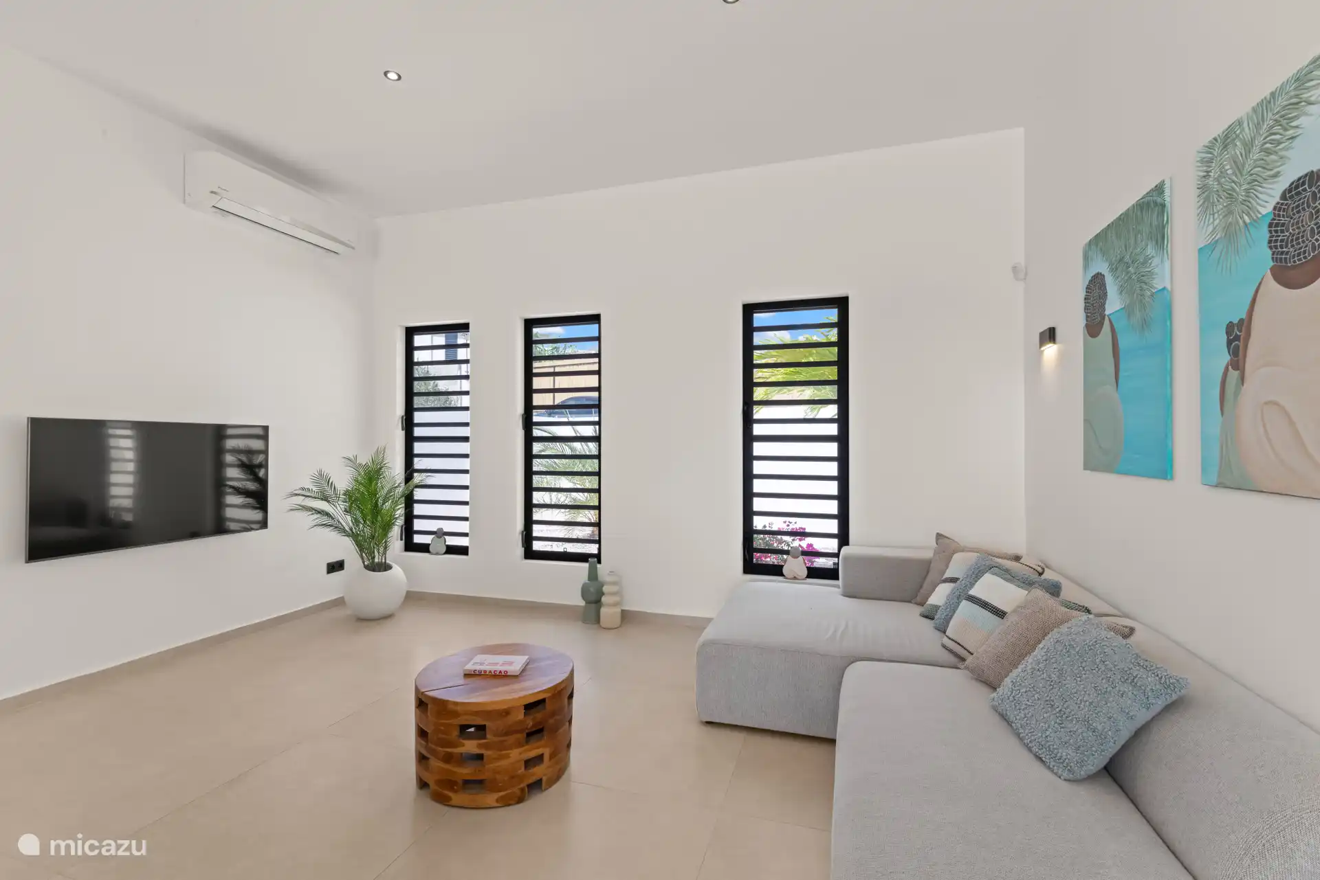 Lichte woonkamer met comfortabele zithoek, airconditioning en veel natuurlijke lichtinval.