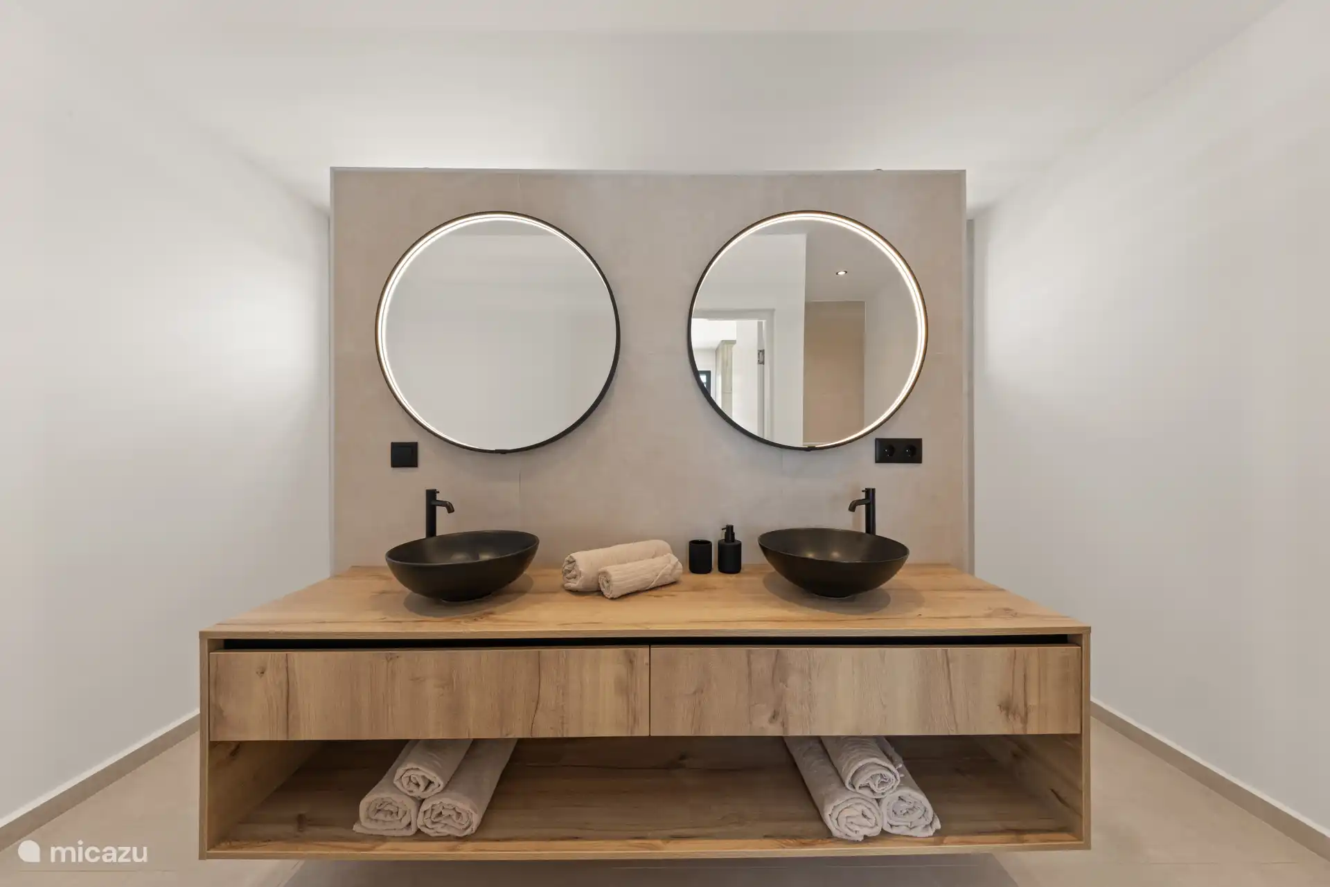 Badkamermeubel met dubbele waskommen en natuurlijke materialen.