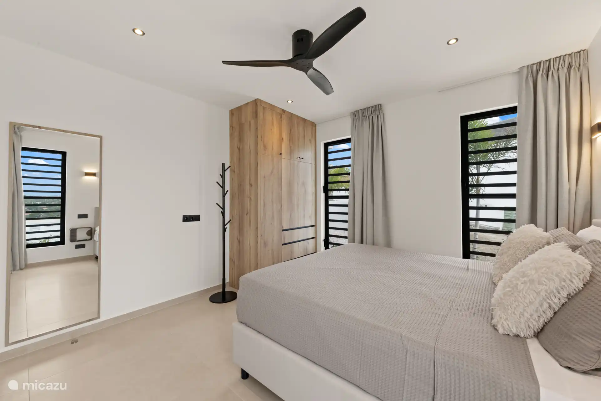 Slaapkamer met veel licht, moderne afwerking en directe toegang tot de badkamer.