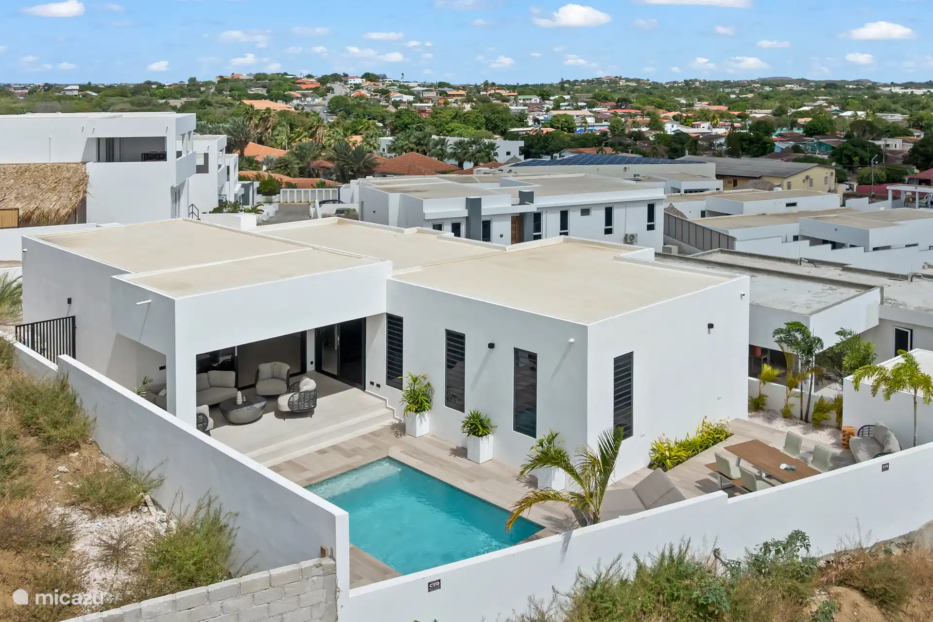 Dronefoto van de villa en de rustige, moderne woonwijk waarin de accommodatie ligt.