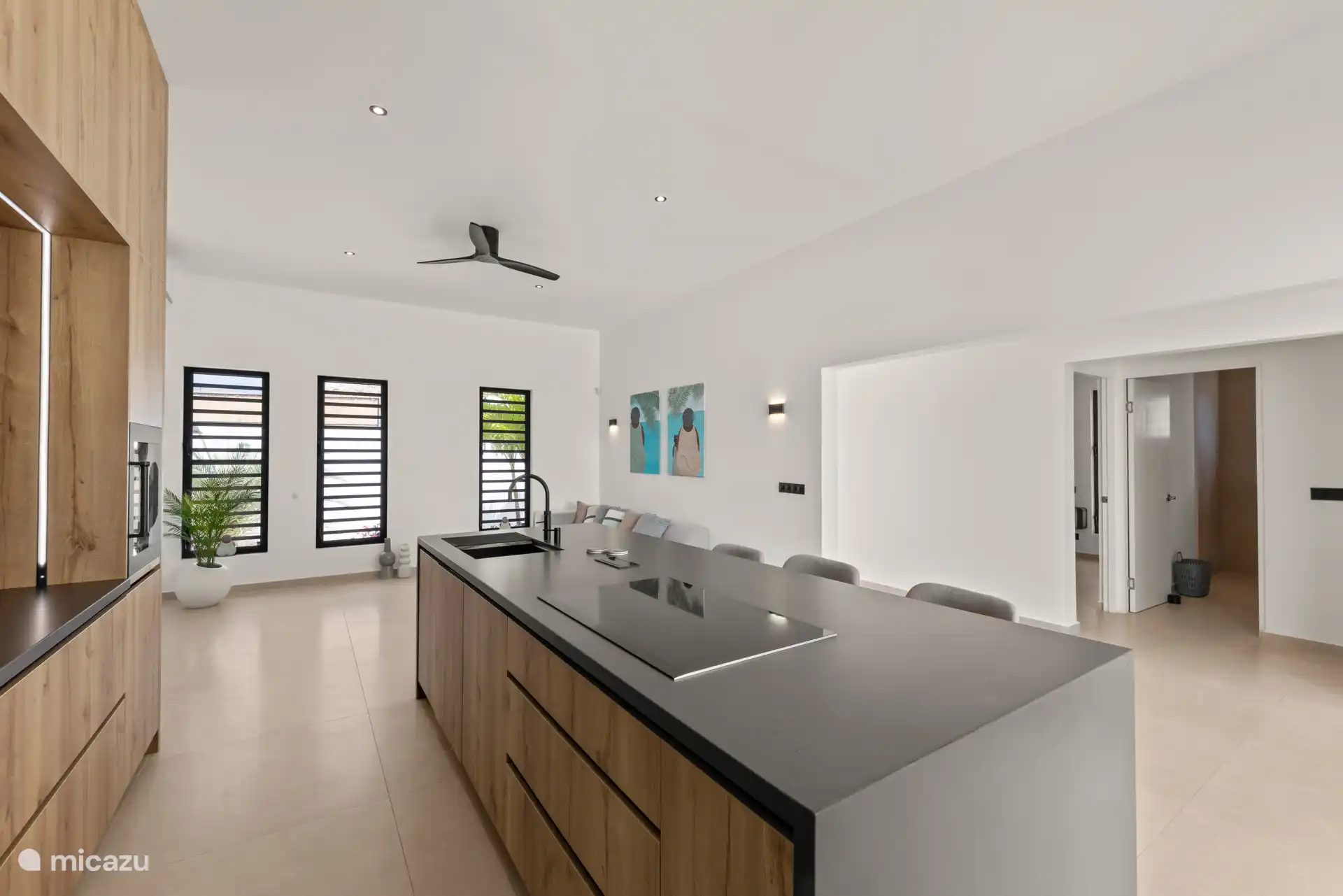 Open keuken met kookeiland, moderne apparatuur en een ruimtelijke opzet.