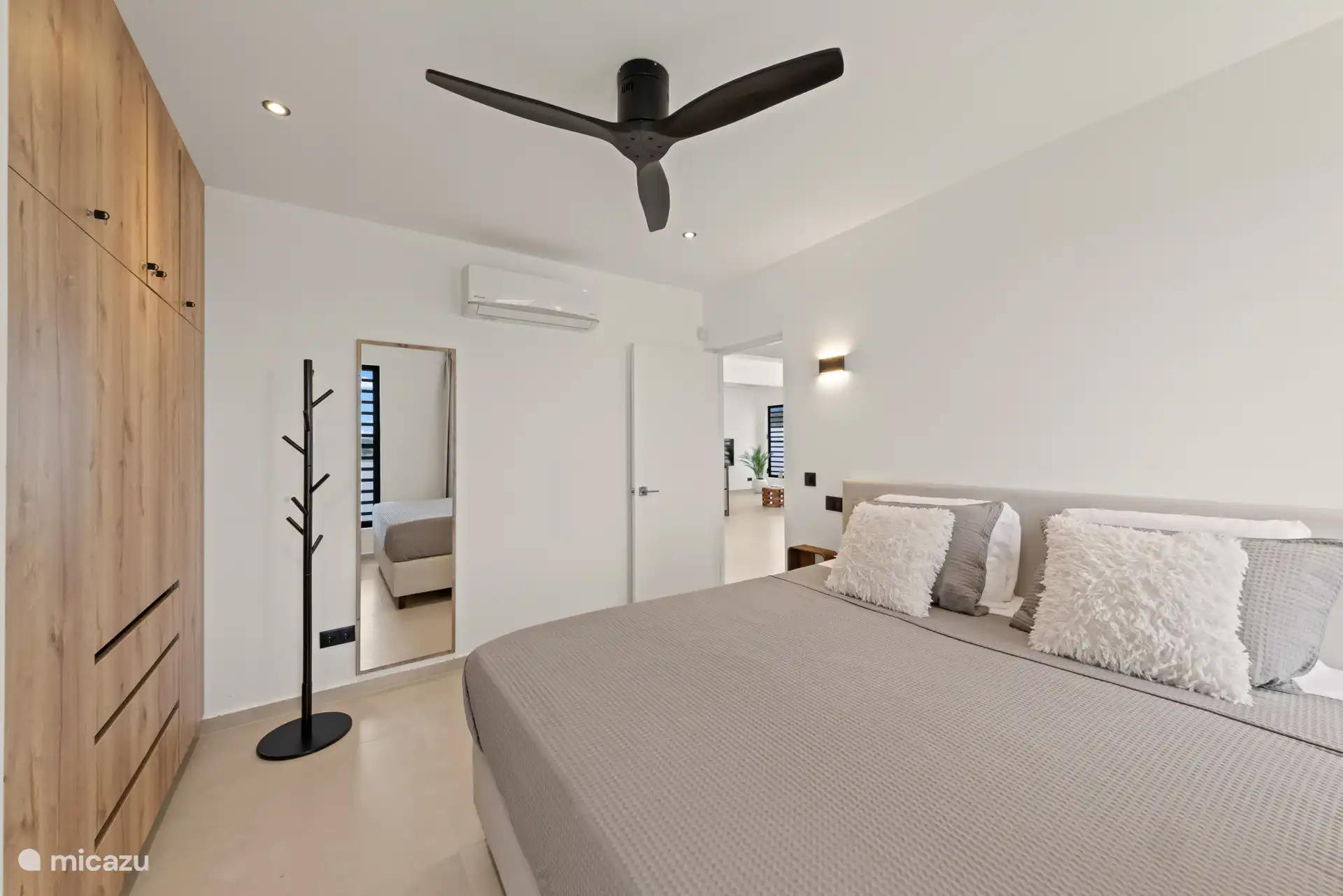 Ruime slaapkamer met airconditioning, plafondventilator en moderne details.