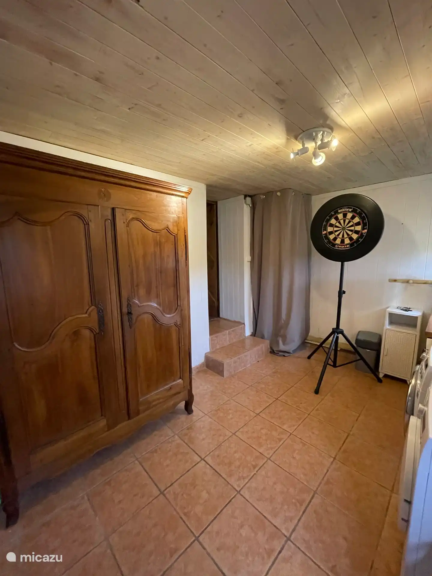 Dartbrett und Schrank mit Vorräten im Hauswirtschaftsraum.