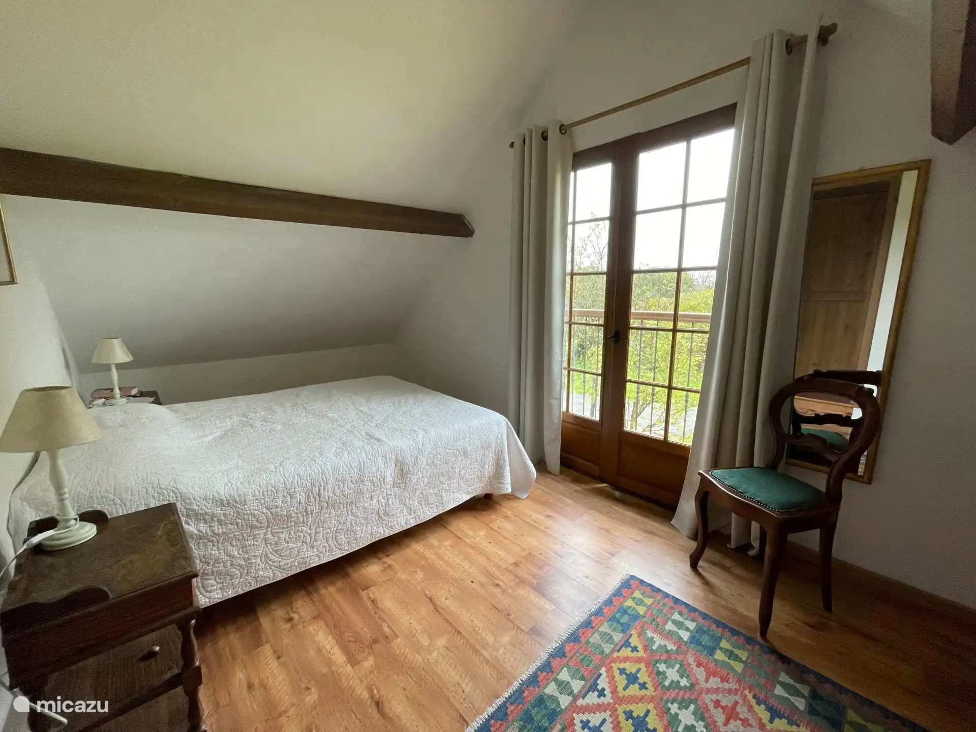 Das Schlafzimmer mit Blick auf den Pool und die Wiesen. Die Türen sind französische Türen. 