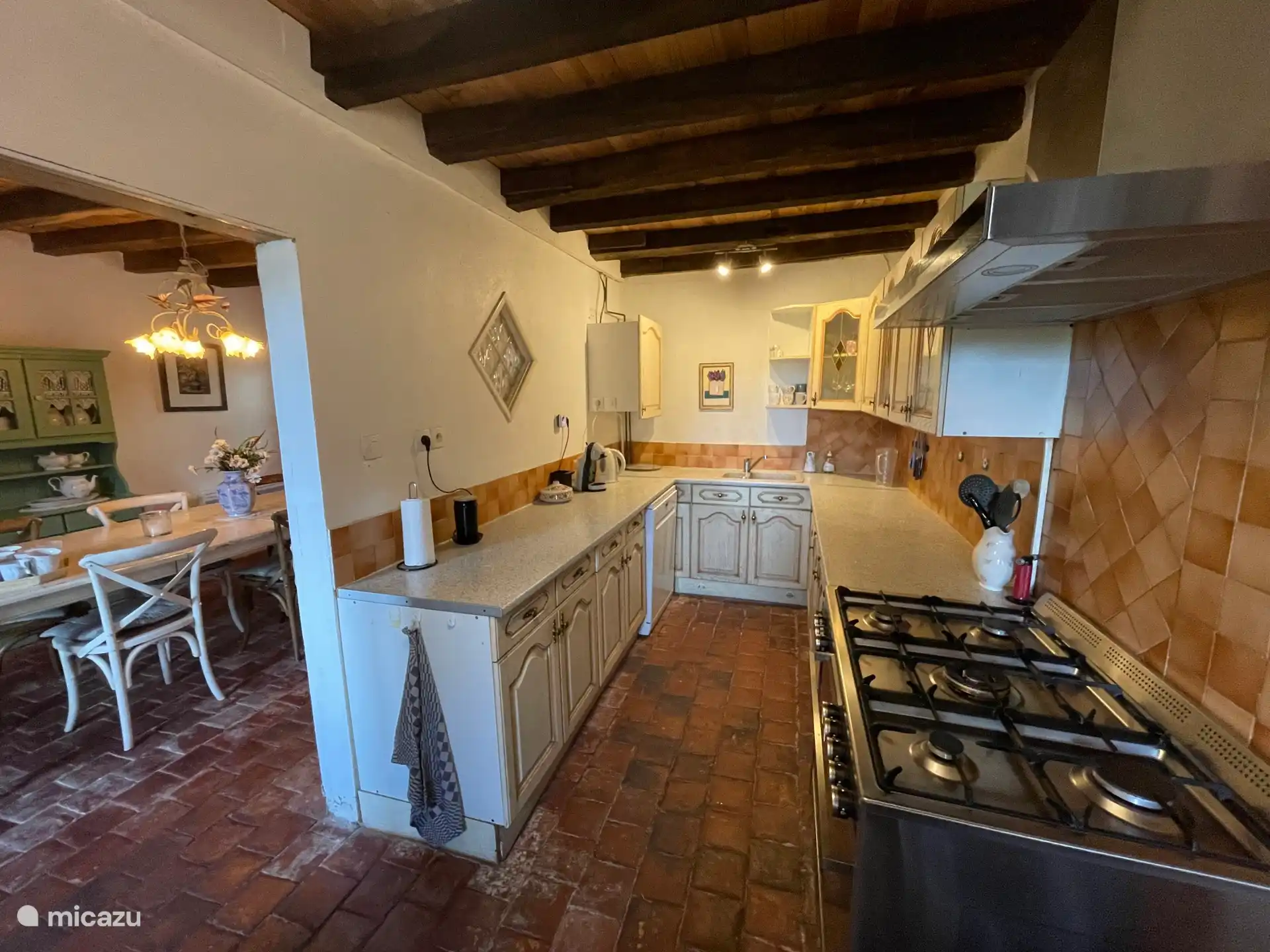 Die Küche mit dem großen Herd und Blick auf das Esszimmer nebenan.