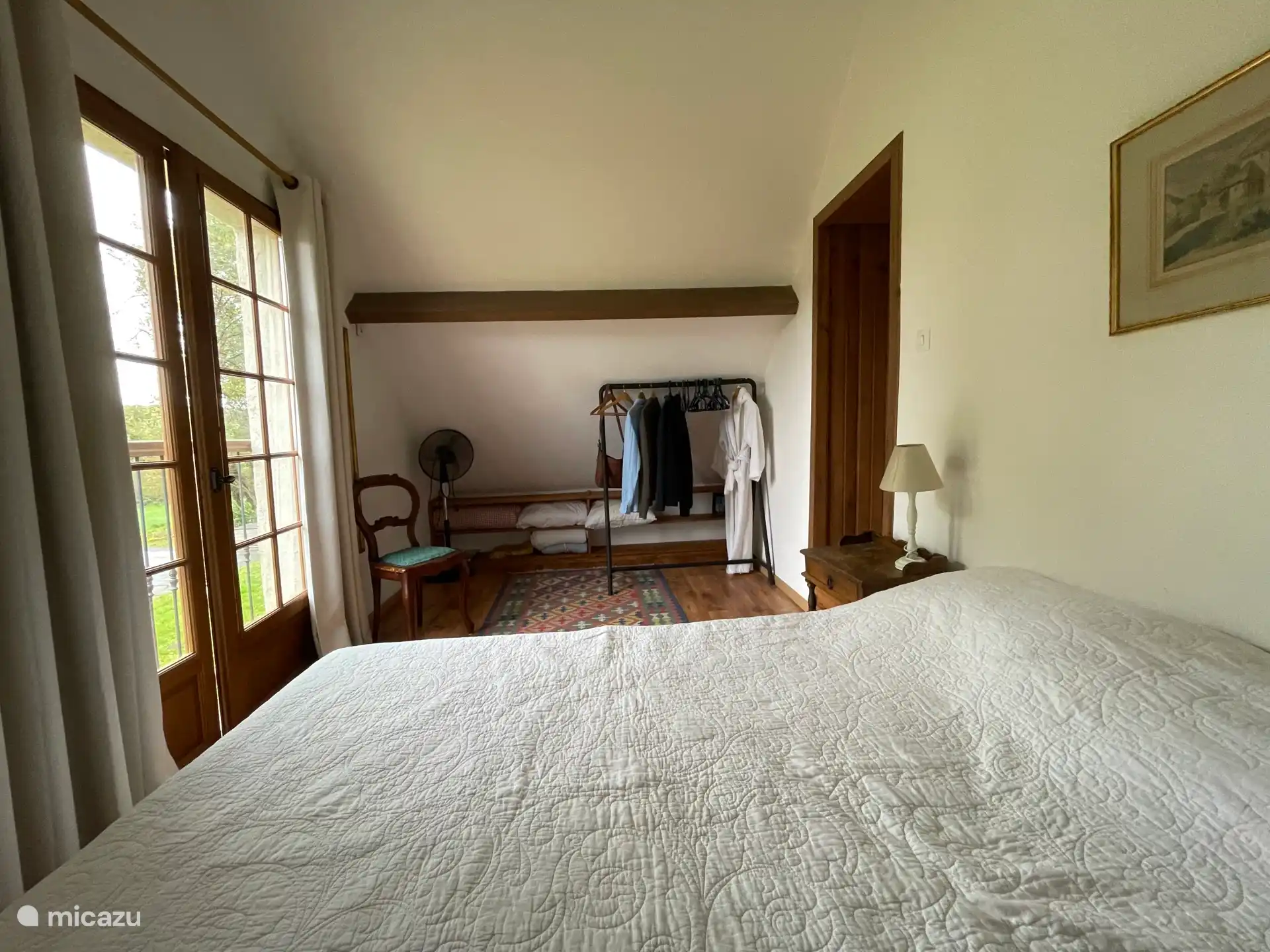 Schlafzimmer 1 mit Wäscheregal und Terrassentüren.