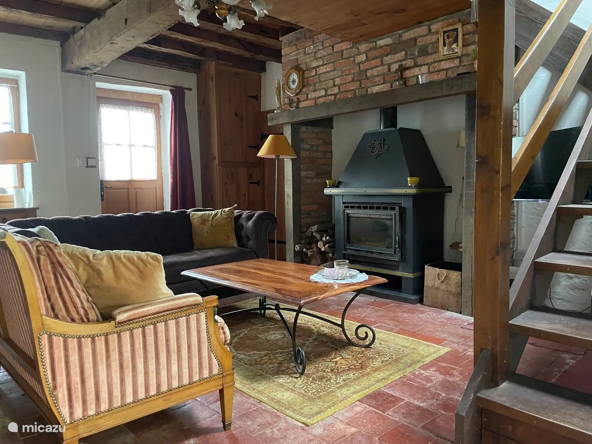 Das Wohnzimmer mit Holzofen und rechts die Treppe ins Erdgeschoss.