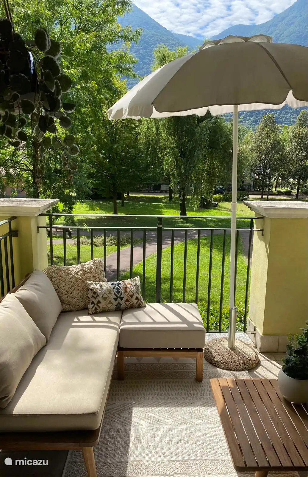 de lounge-plek op het balkon, met uitzicht op de mooie binnentuin en de bergen