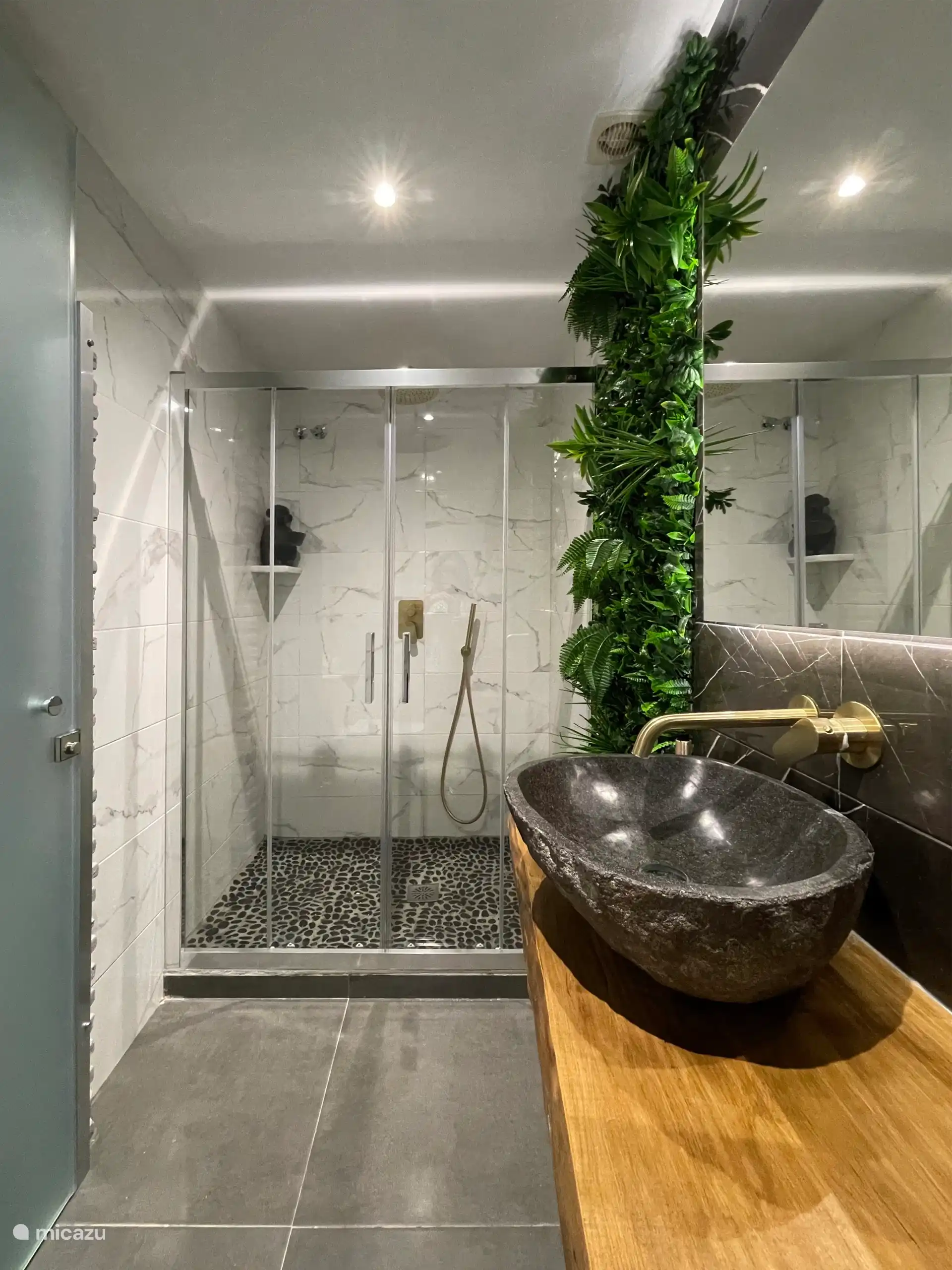 Rainforest badkamer met douche, toilet en wastafel.