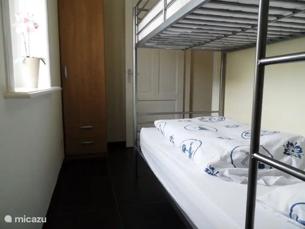 kleine slaapkamer met stapelbed en opbergkast