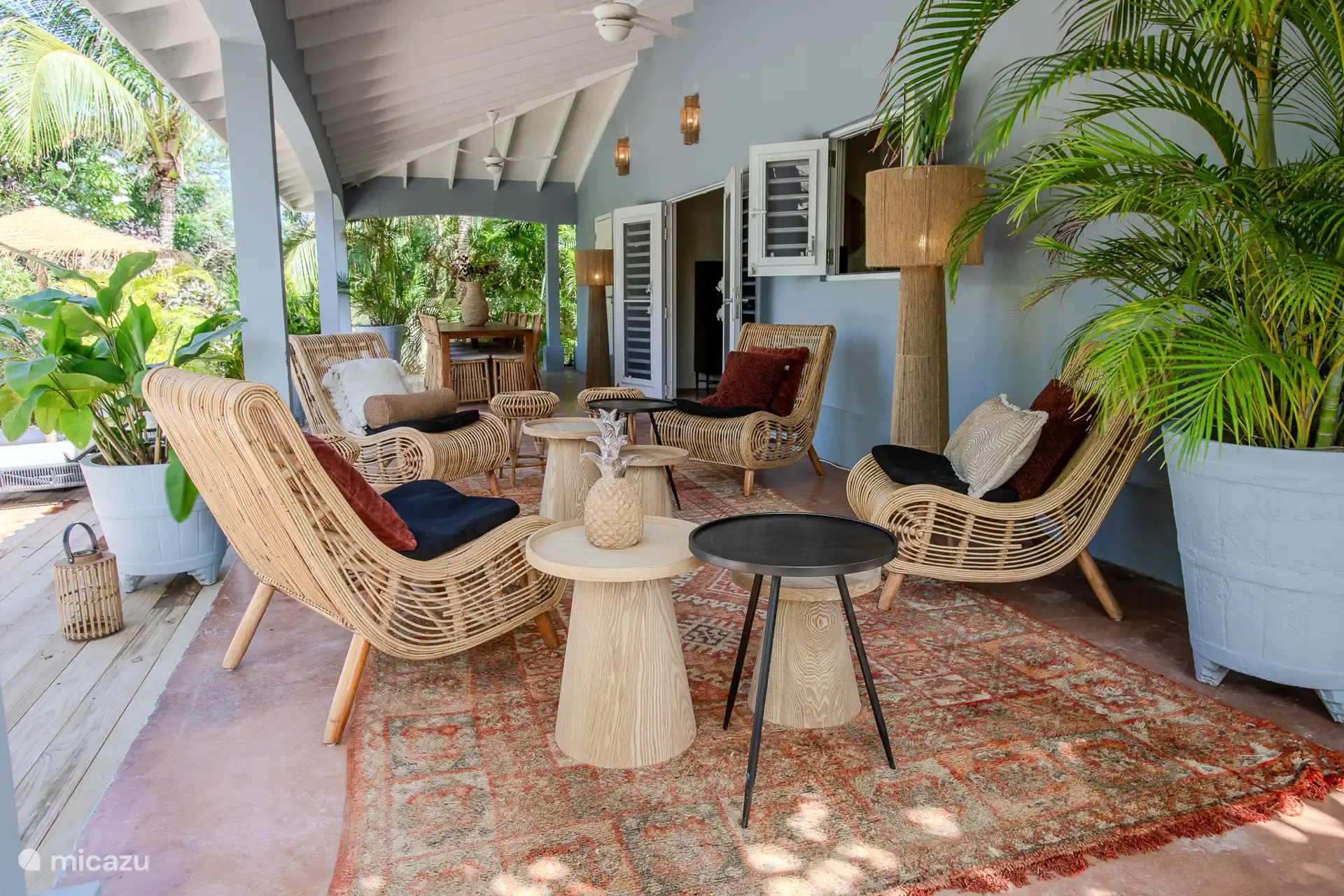 Zona de descanso en el porche con preciosos sillones de ratán para acurrucarse